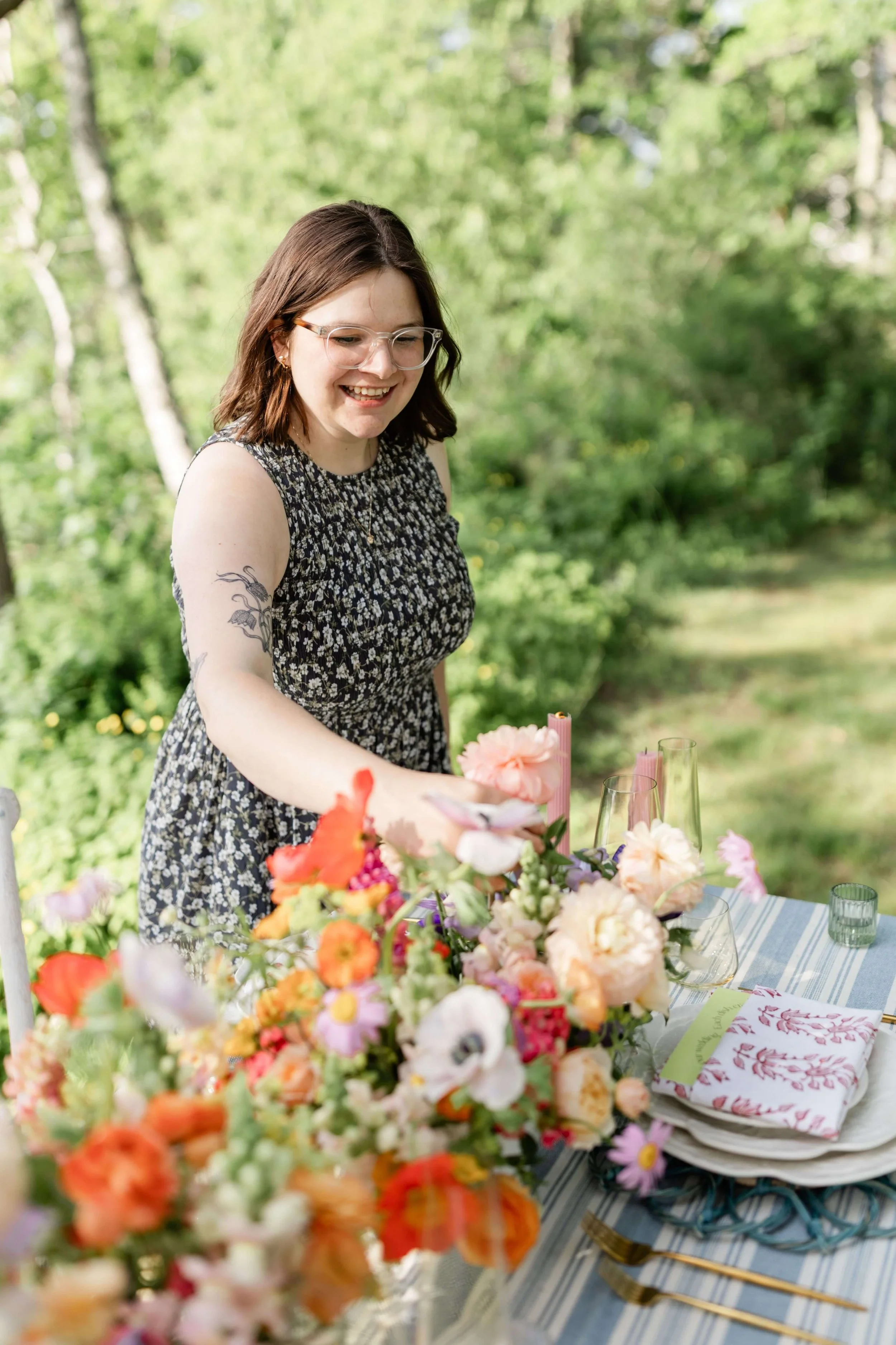 Milkweed Floral Co founder arranging a vibrant garden-inspired tablescape with peonies, poppies, and anemones at Harpswell Inn, Maine