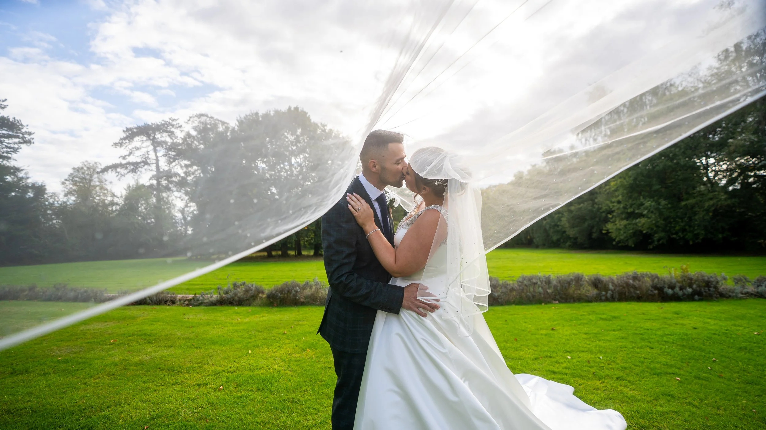 Rowton Hall Hotel and Spa wedding photography Chester, Couple under veil kissing