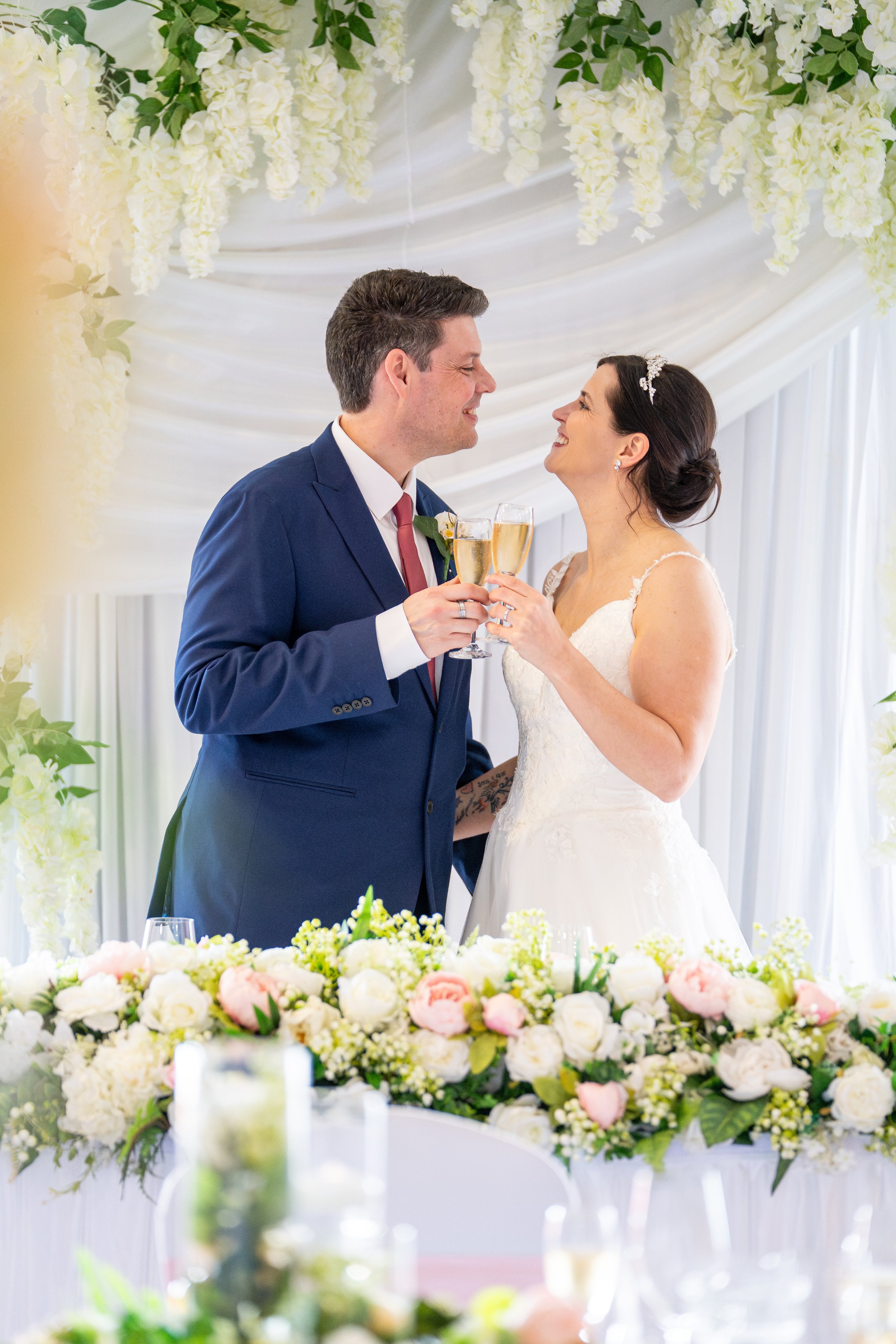 A bride and groom having a romantic timeless portrait taken in a fully dressed room at the wirral wedding venue the Holiday Inn, Ellesmere Port