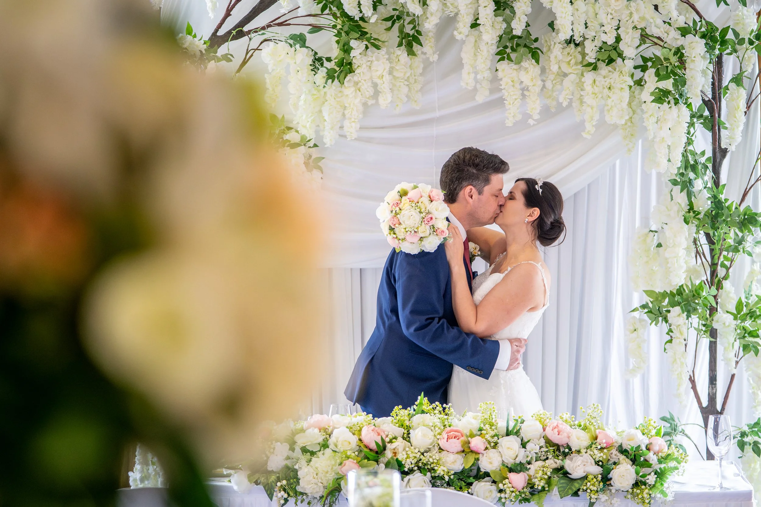 A bride and groom having a romantic timeless portrait taken in a fully dressed room at the wirral wedding venue the Holiday Inn, Ellesmere Port