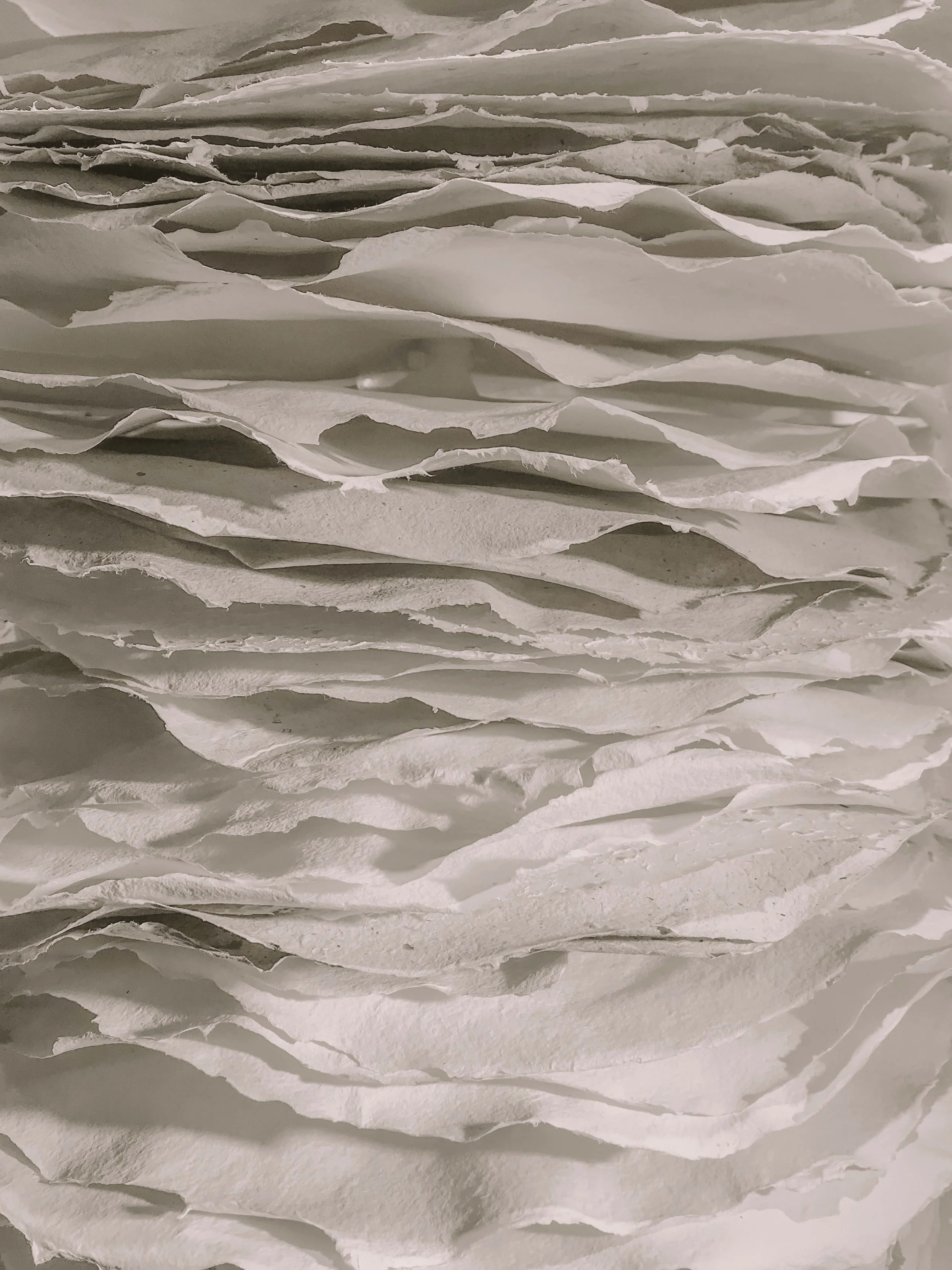 Close-up of layered torn white paper sheets.