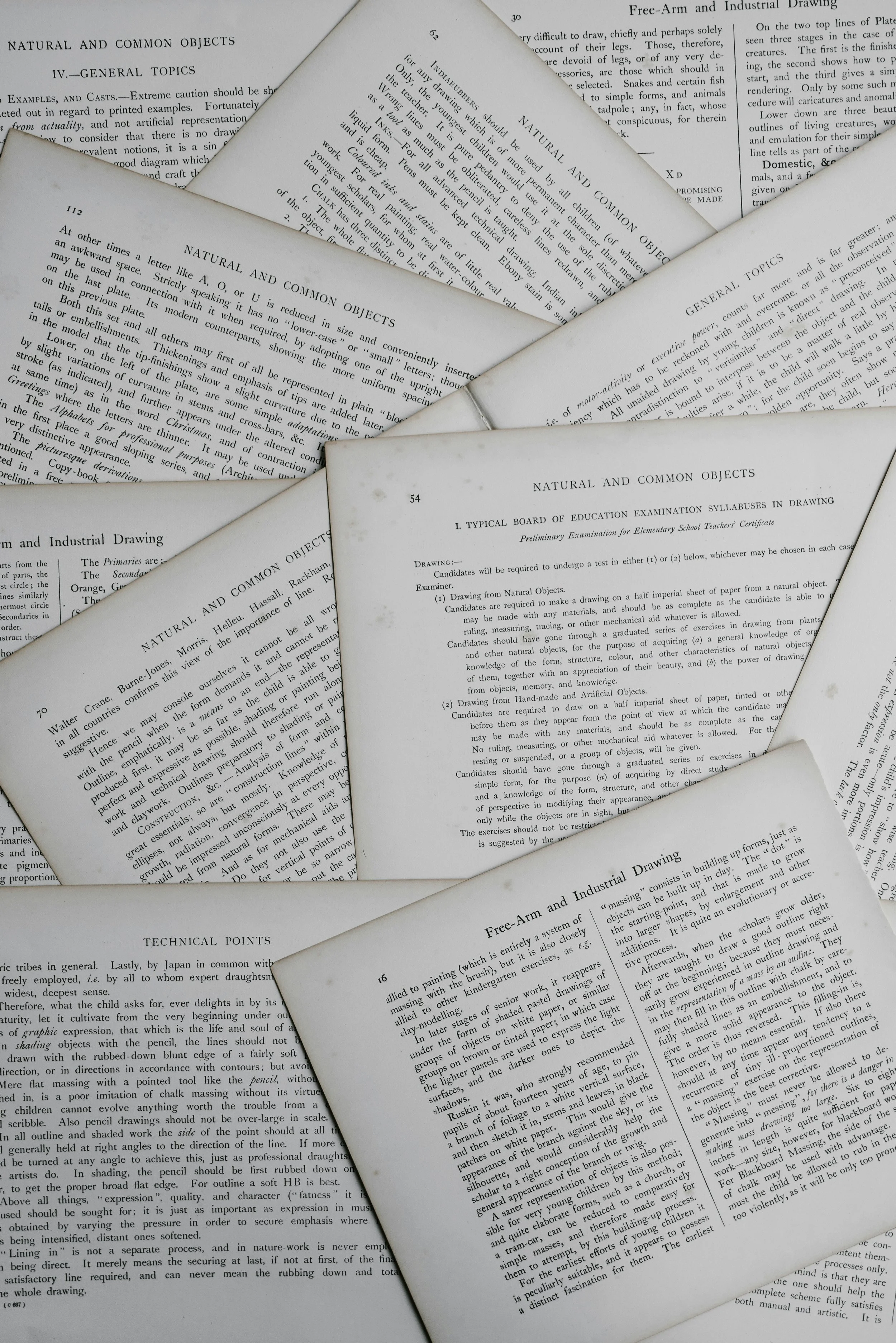 Close-up of overlapping pages from a book on natural and common objects, showing text related to drawing techniques, examination syllabi, and technical points.