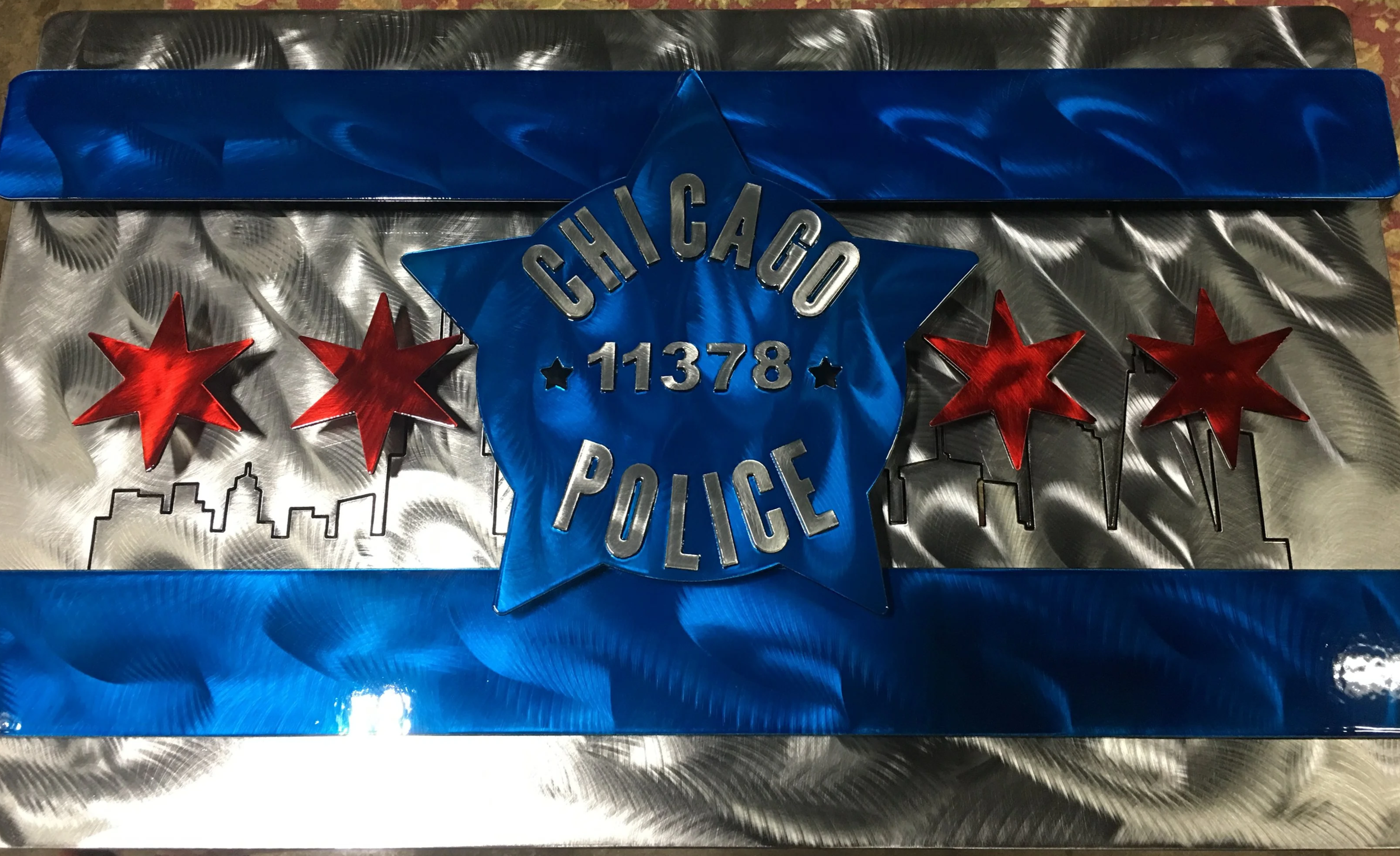 Chicago Police badge with stars and city skyline design on metallic background.