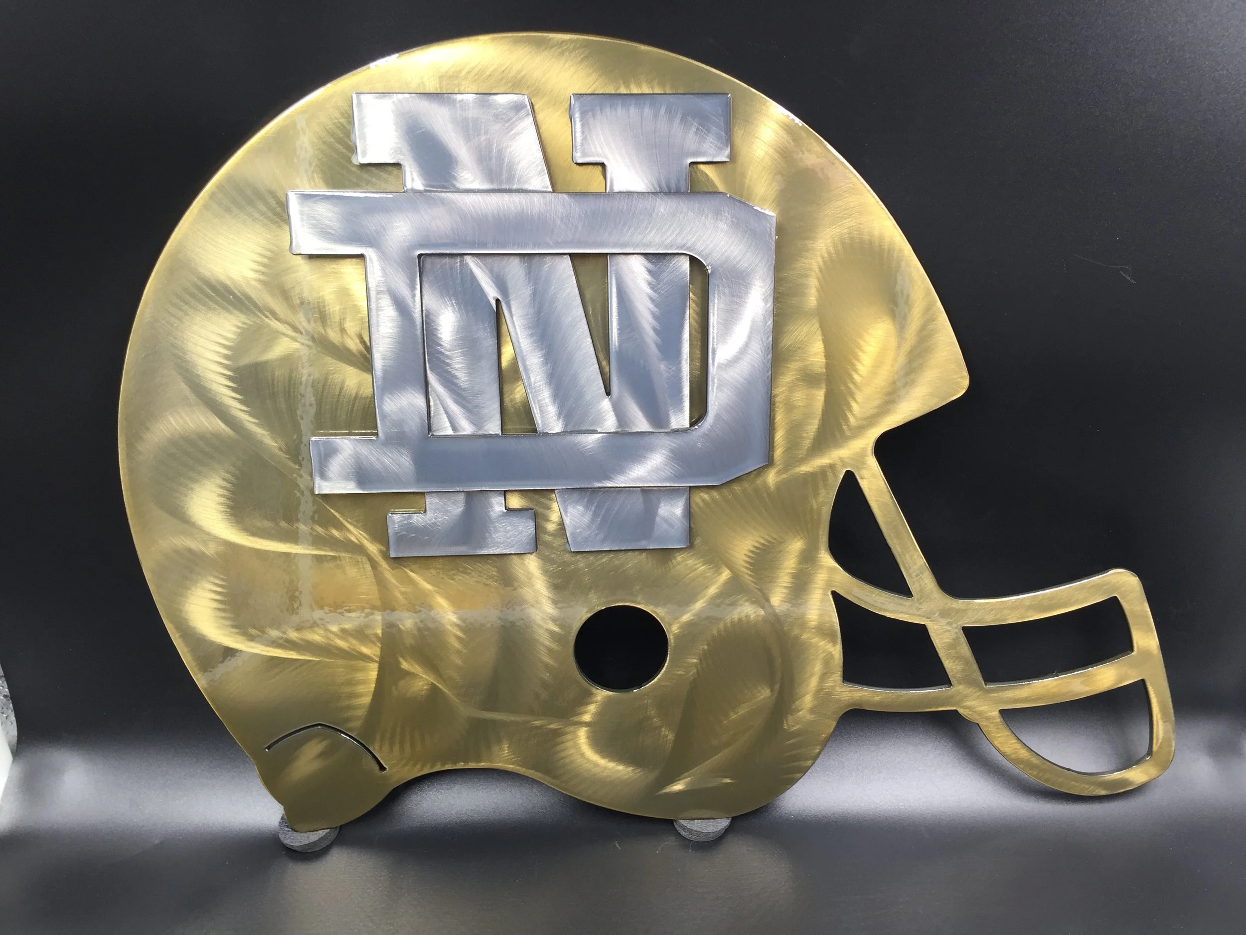 Decorative football-shaped item with a Boston College logo and a speech bubble outline, made of metallic materials, gold and silver colors.