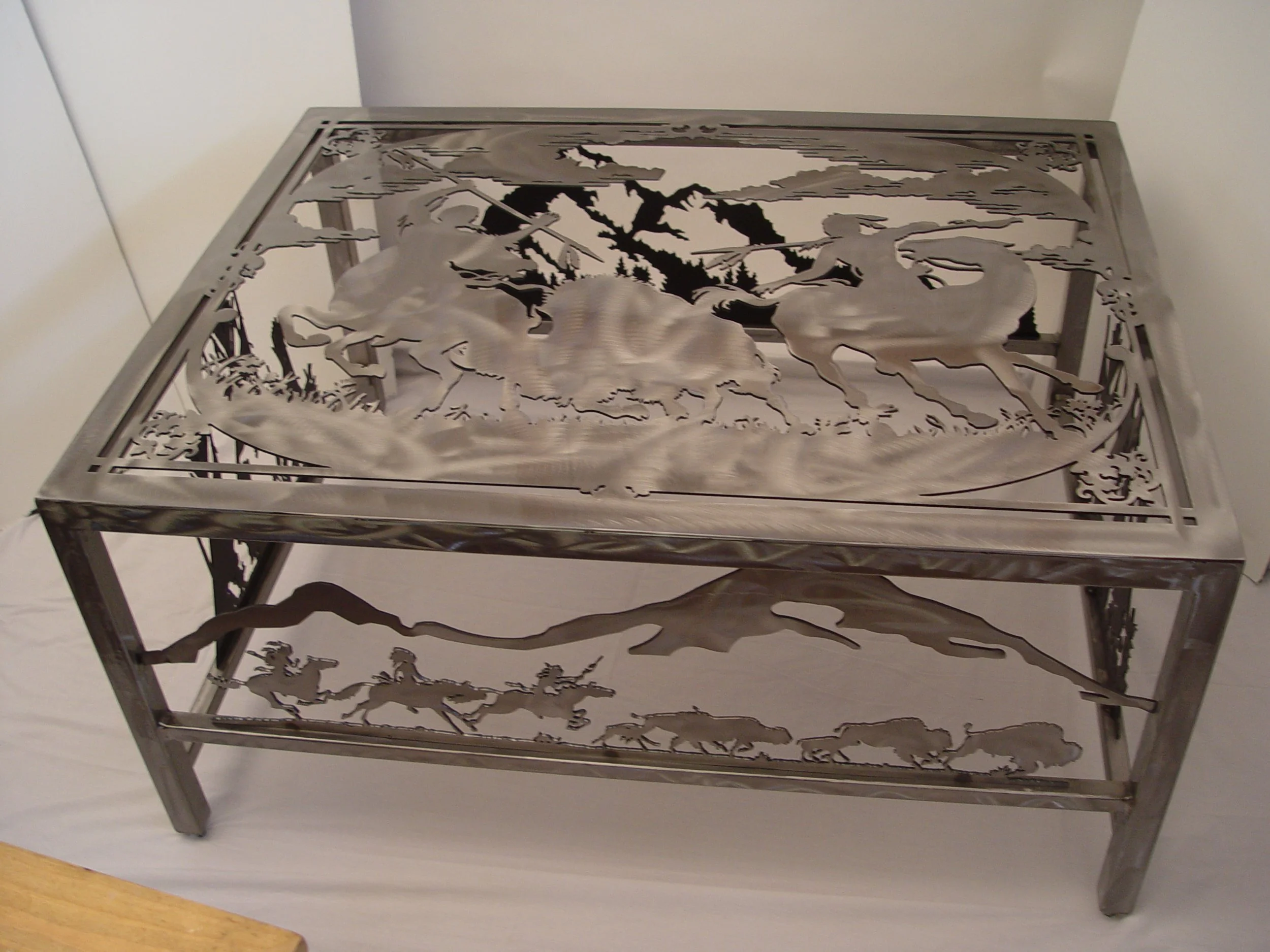 Metal table with landscape cutout designs featuring wolves and trees