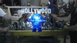A television studio or set with a large Hollywood sign and a blue character statue in front of it.