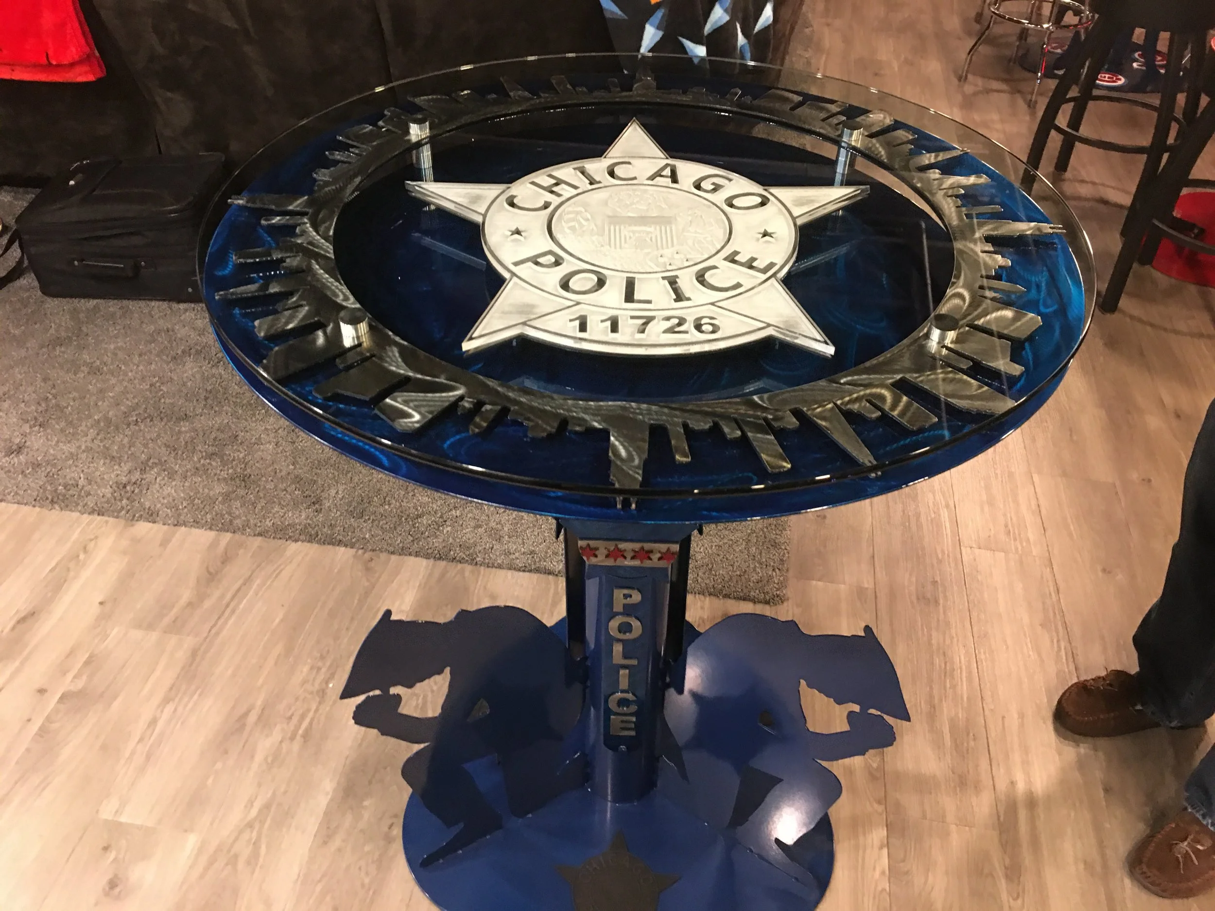 A table with a glass top featuring the Chicago Police badge in the center.