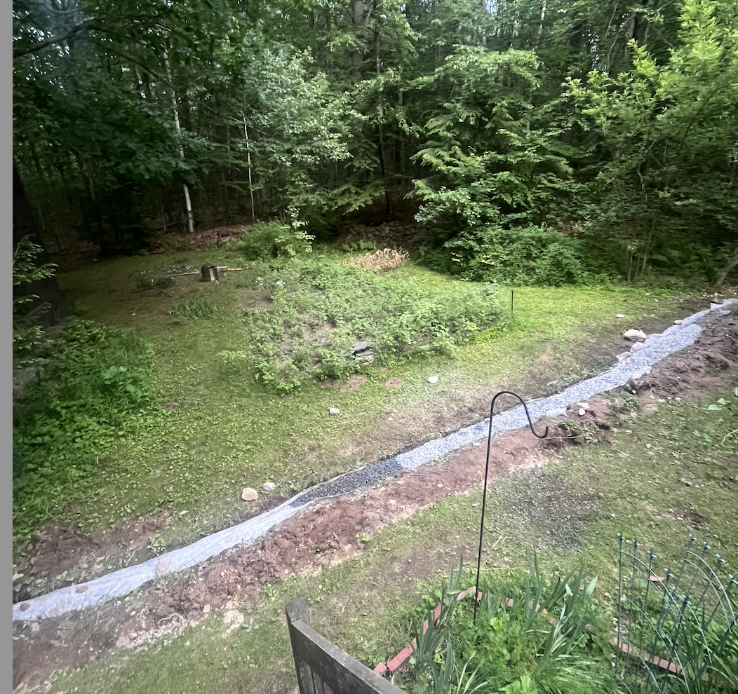 After the trench was officially deep enough, we layered some crushed stone, inserted the perforated pipe and covered it with more crushed stone and lastly, the weed preventing, eco-friendly, filter fabric.