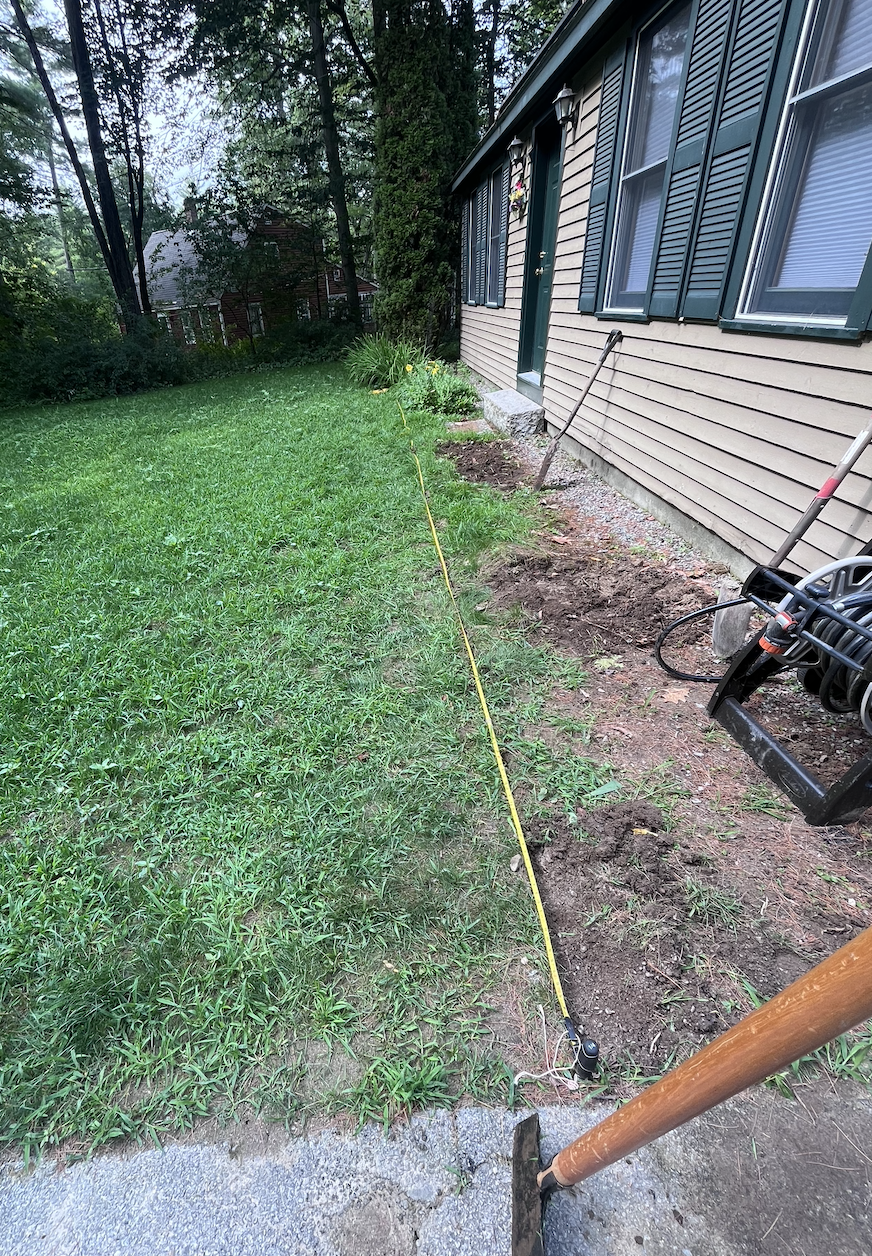 Measuring the distance of both the walk way and our new foundation mulch bed that we were going put in after.
