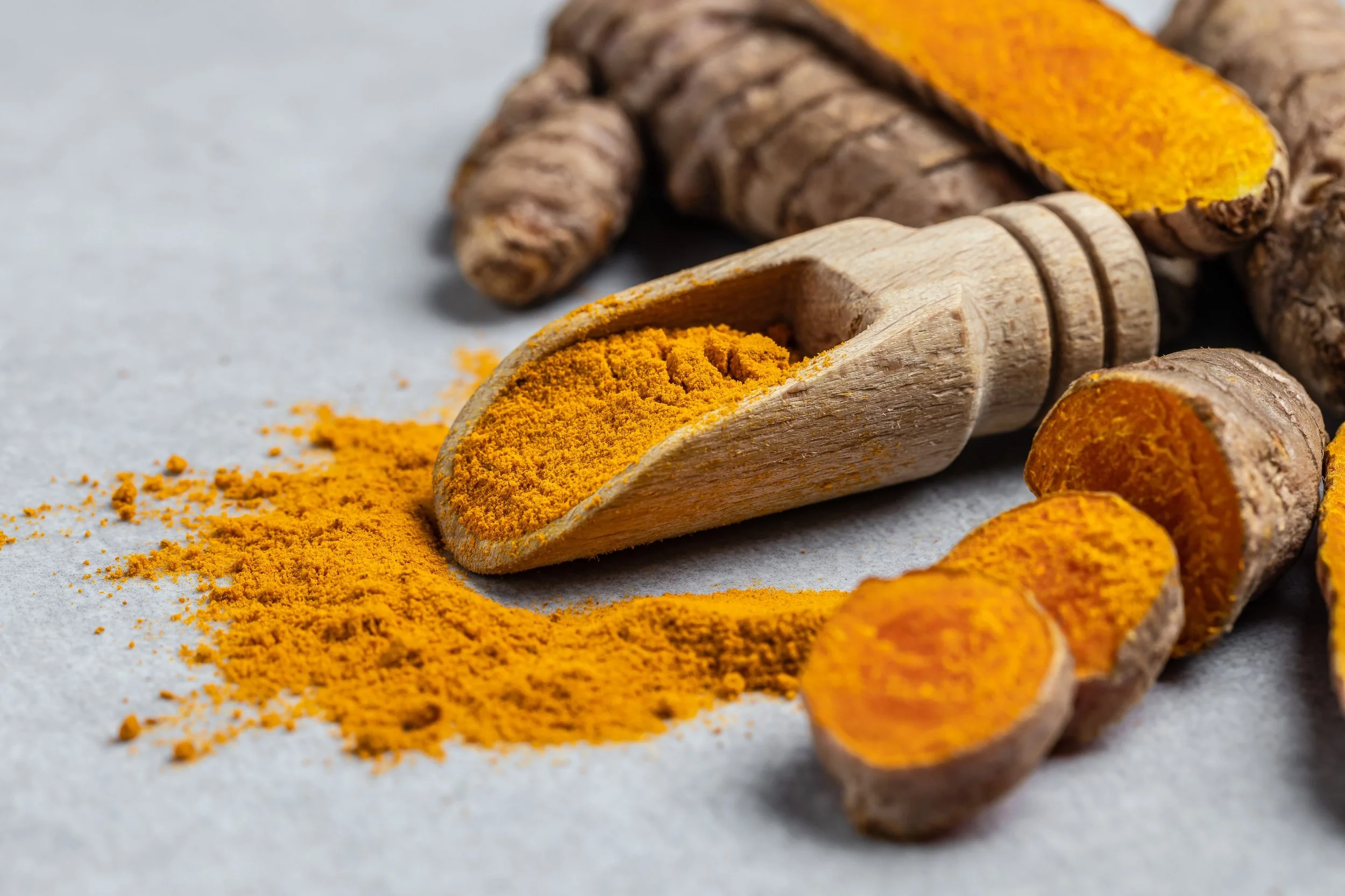 Close-up Turmeric curcumin powder in wooden spoon