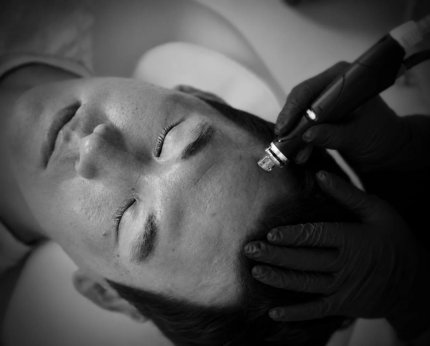 HydraFacial image of a patient receiving the facial with a picture of Brice performing the skin treatment. Medical grade facials. Facials for men. Facials for anti-aging.  Facials for mature skin.  Facials for women.  Customizable facials. Skin Glow.