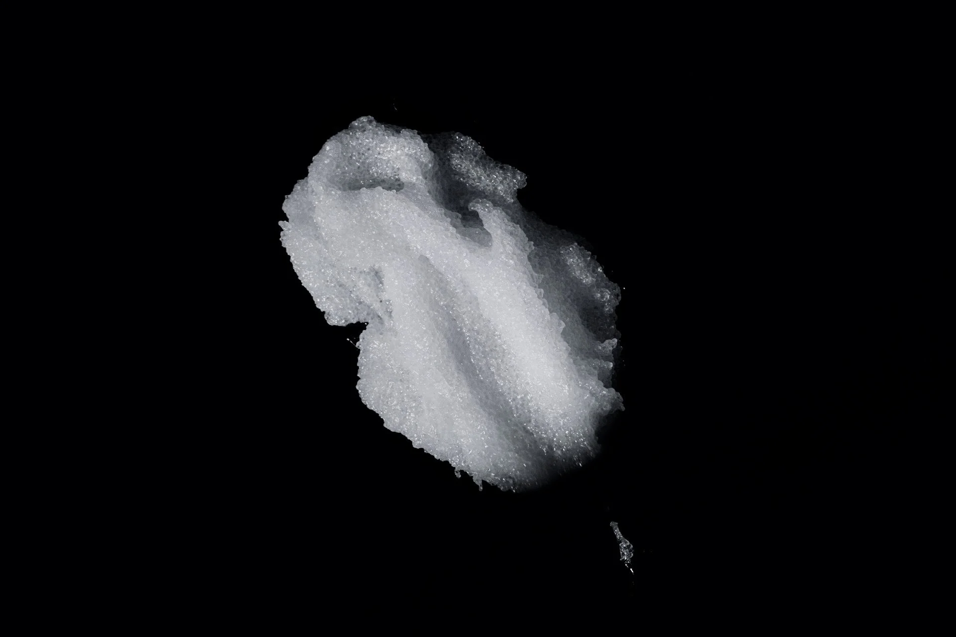 A close-up of a soap bubble floating against a black background.
