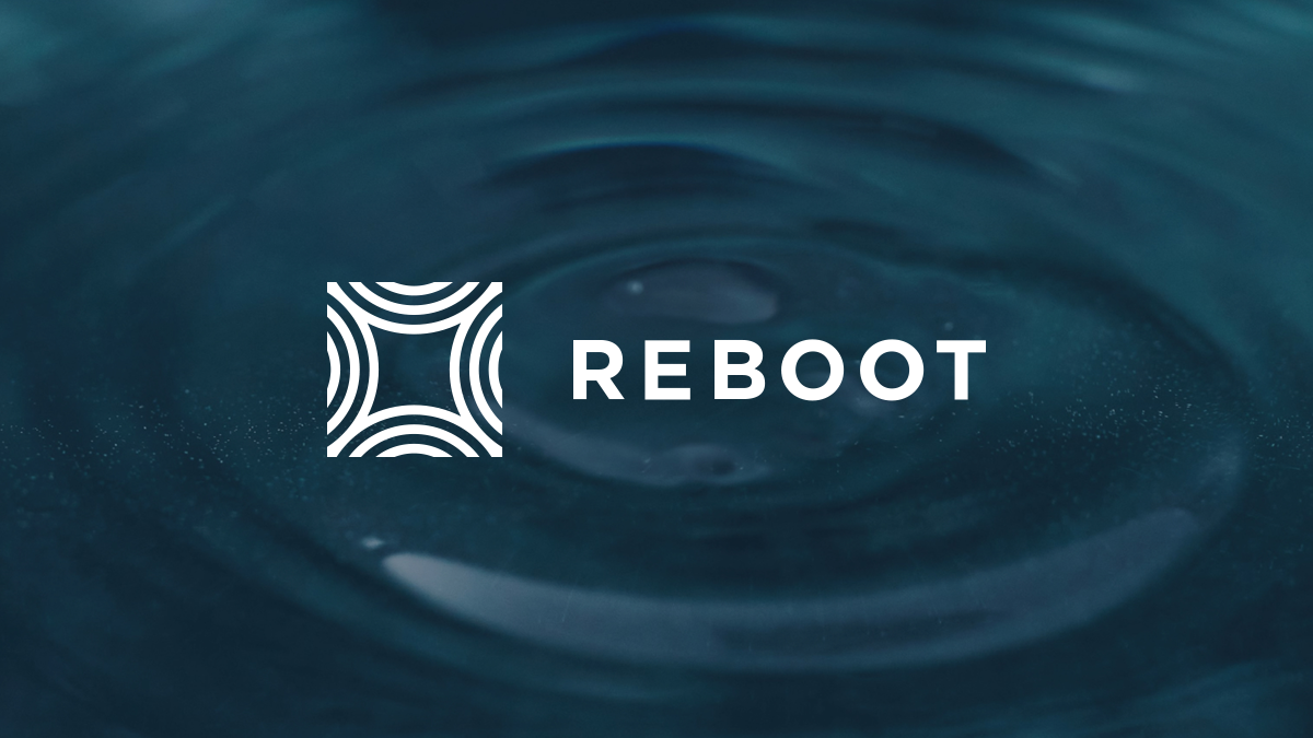 The image shows a close-up of a water surface with a ripple effect, and the word REBOOT with a circular geometric logo beside it.