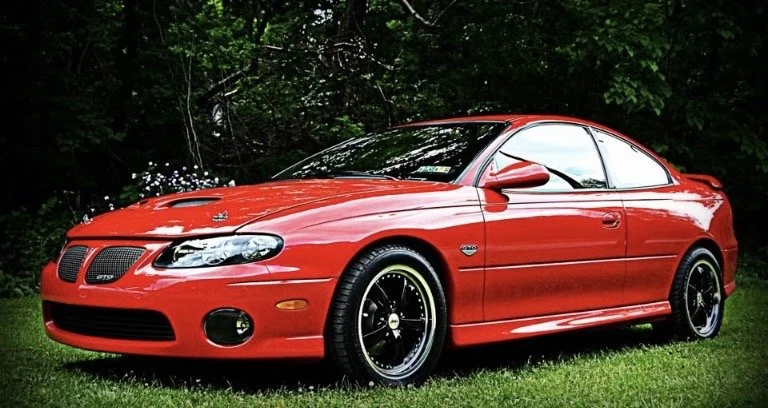Red Pontiac GTO with exterior detailing and tire dressing