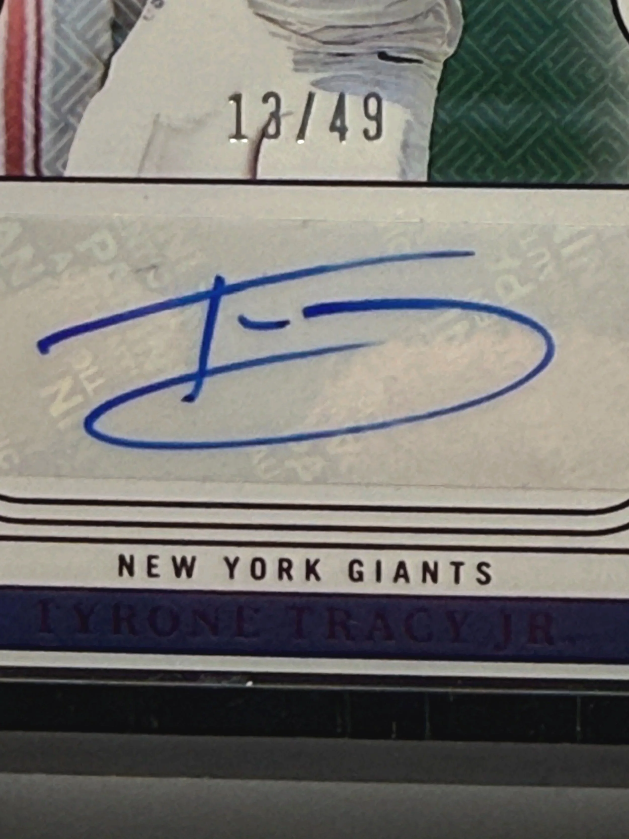 Top left corner close-up of 2024 National Treasures Tyrone Tracy Jr Rookie Auto Purple /49 card showing autograph and serial numbering