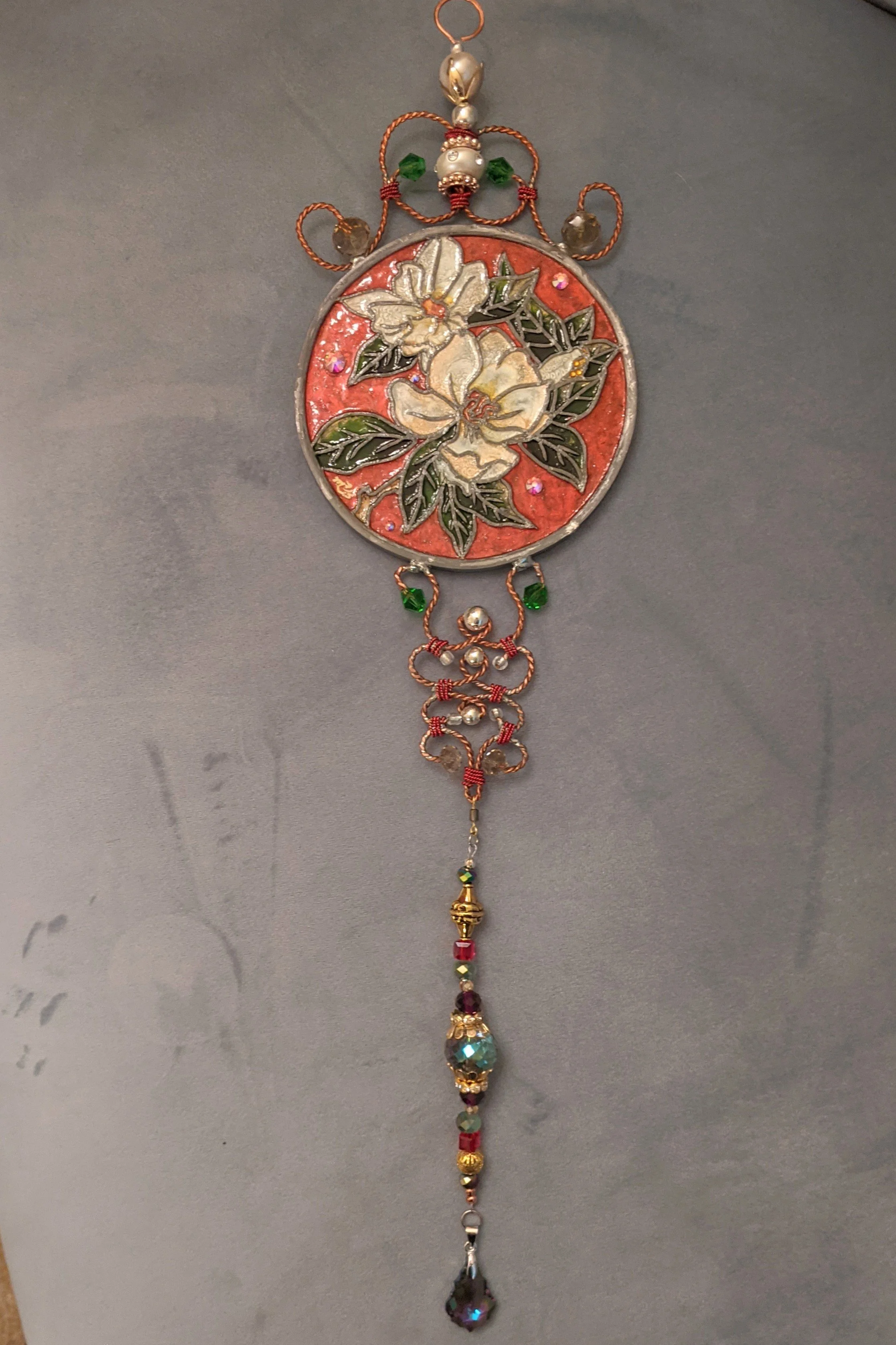🔴 Sold: 
Magnolias Illusion Glass by Art Illusions by Young. Creamy white magnolia blossoms with lush green leaves fill this round suncatcher, evoking the Southern elegance of Louisiana gardens. The soft, painterly style creates a gentle, luminous e