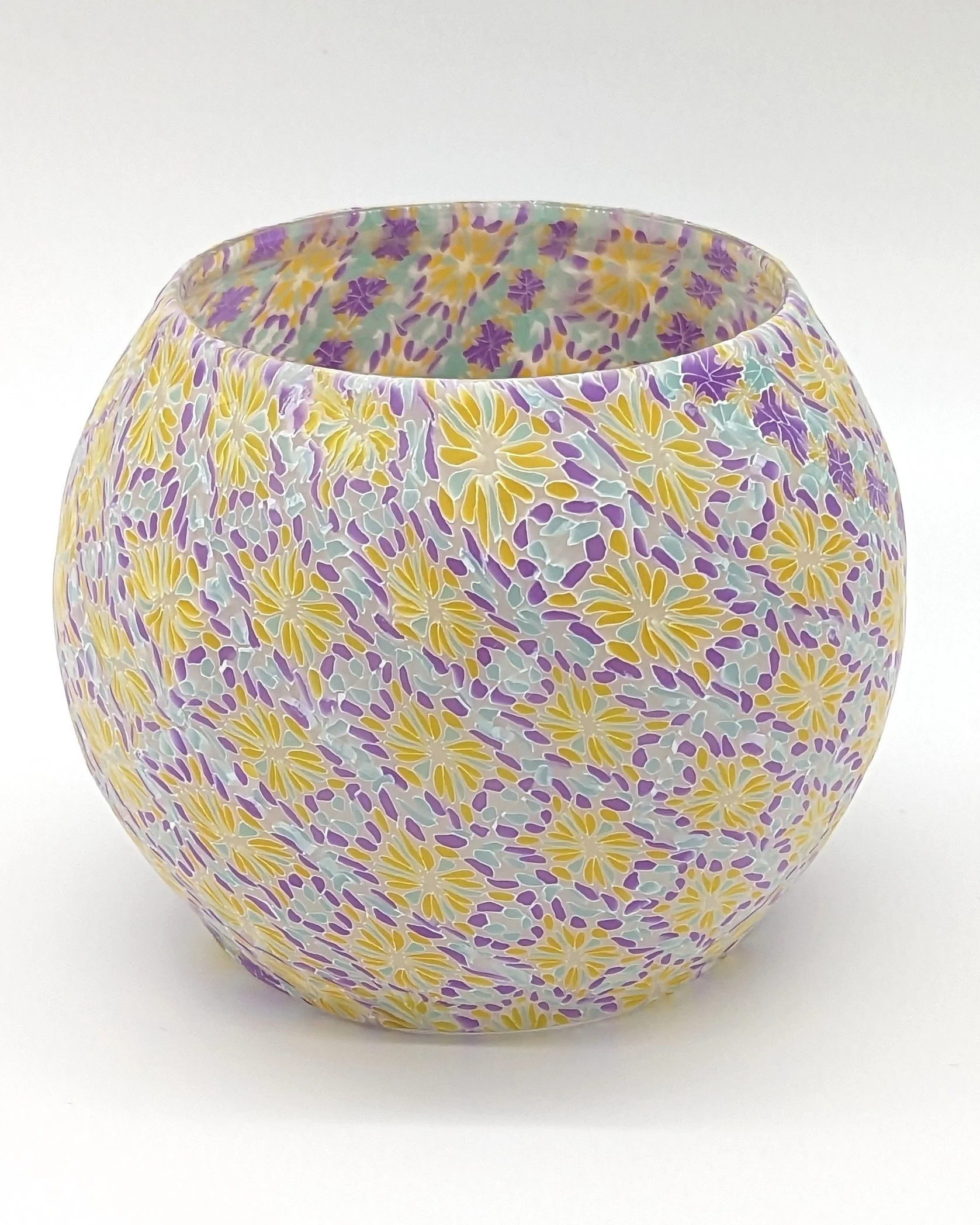 🟢 Available :
Translucent Floral Candle Holder by Art Illusions by Young from Folsom, Louisiana. Layers of translucent polymer clay create delicate overlapping floral patterns in soft purples, sunny yellows, and gentle aqua tones that shimmer with a