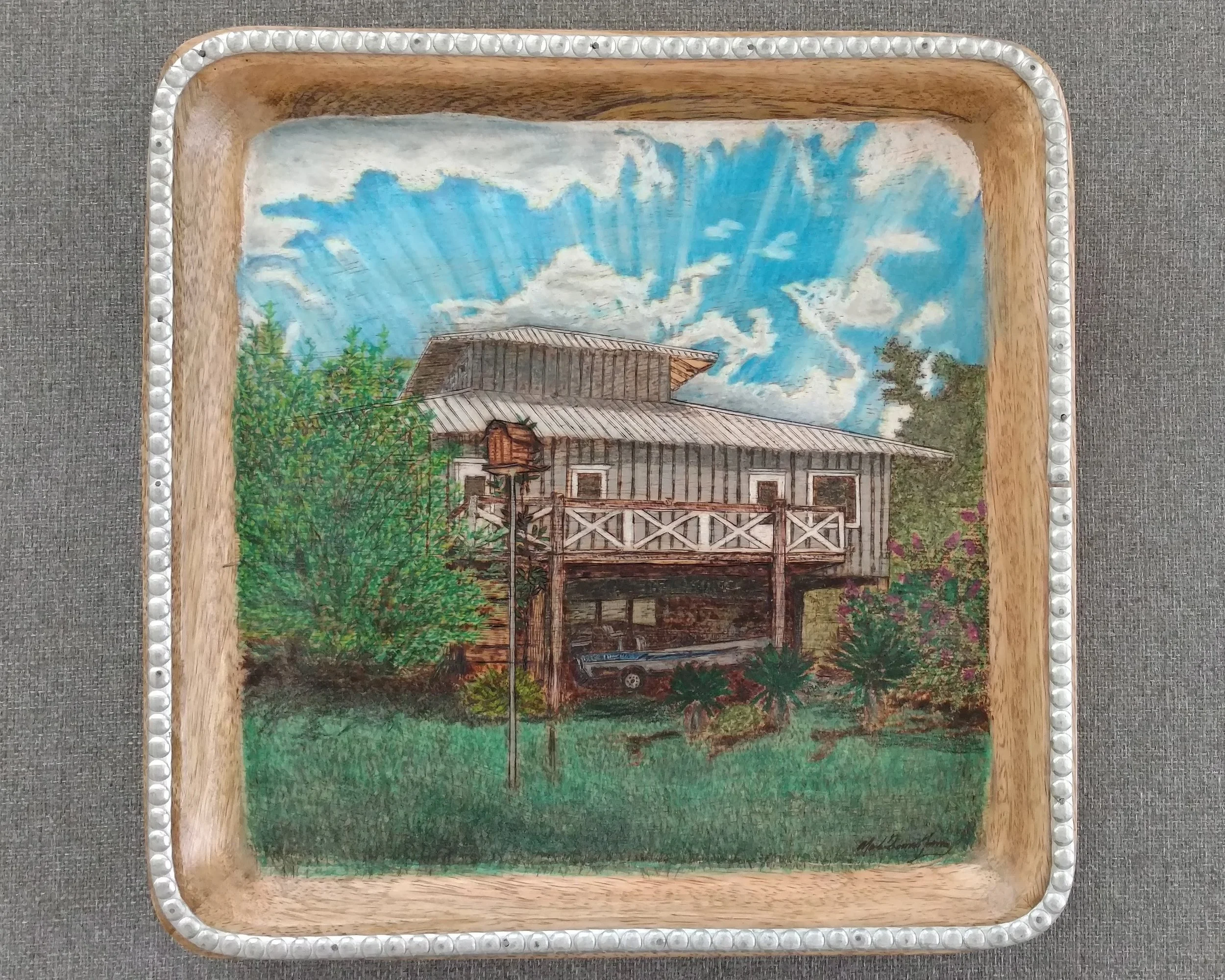 🔴 Sold:
Pass Christian Mississippi Camp Pyrography by Art Illusions by Young, Folsom, Louisiana. This detailed woodburn captures a charming elevated camp house nestled among lush green bamboo under a bright blue sky with fluffy white clouds. The rus