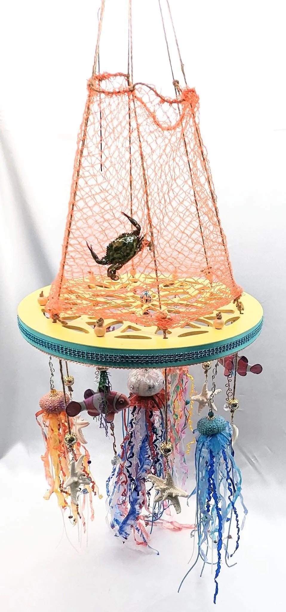 🔴 Sold: 
Undersea Blue Crab Jellyfish Mobile by Art Illusions by Young, Folsom, Louisiana.
This imaginative undersea-themed mobile features a prominent blue crab perched atop an orange fishing net draped over a circular platform, evoking the wonder 
