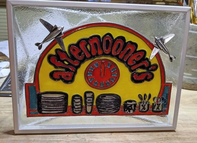 🔴 Sold: 
Afternooners Restaurant Illusion Glass by Art Illusions by Young. This nostalgic circular piece depicts the iconic “Afternooners” restaurant sign with airplanes to highlight the Central Nebraska Regional Airport restaurant. Vibrant colors a