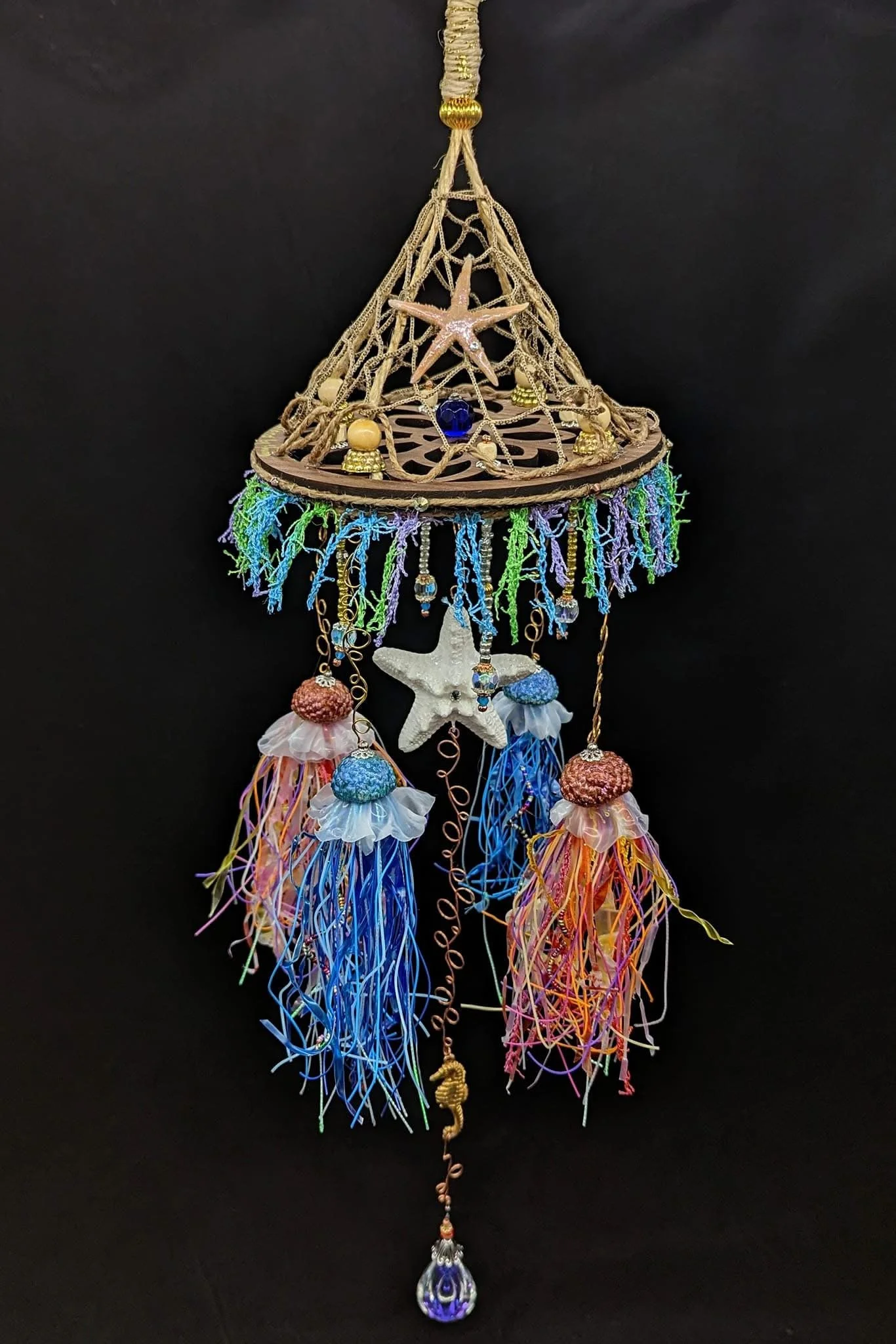 Full hanging view of the Jellyfish Mobiles – Chihuly-Inspired Light Catcher by Art Illusions by Young. Measuring approximately 6” wide by 26” long, this impressive mobile features a netted canopy with four miniature Chihuly-inspired jellyfish, resin-