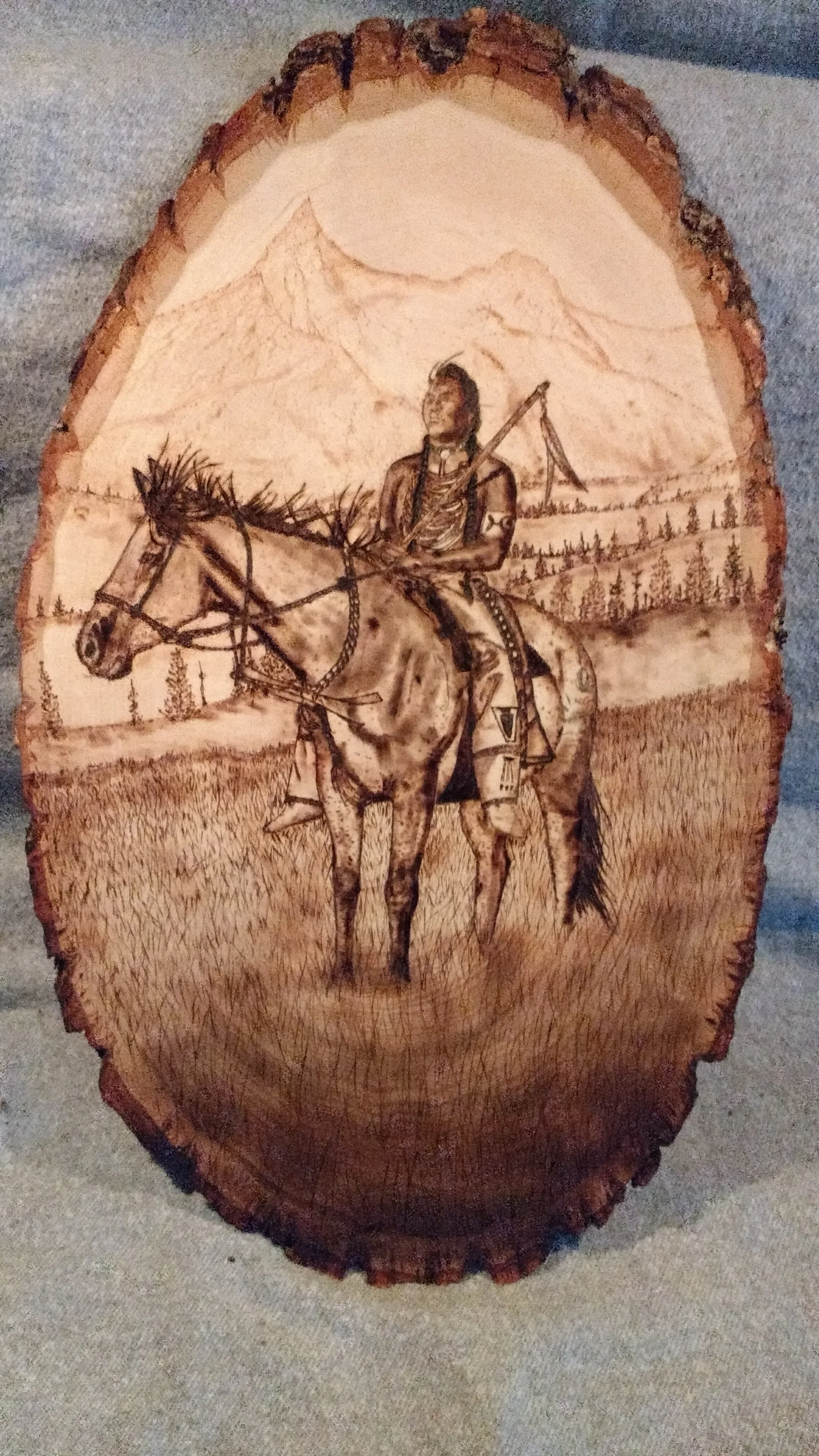 🔴 Sold:
Native American at Bear Pass Pyrography by Art Illusions by Young, Folsom, Louisiana. This evocative woodburn on a natural wood slice captures a Native American rider on horseback at Bear Pass, with the figure silhouetted against a dramatic 