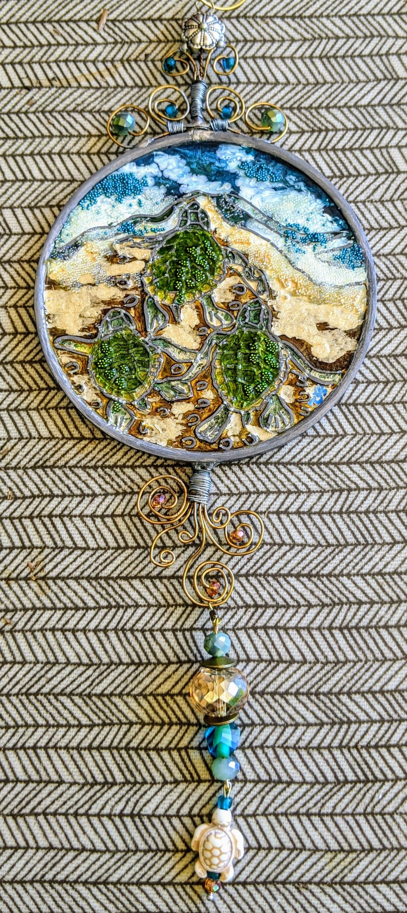 🔴 Sold: 
Baby Sea Turtles Racing to the Ocean Illusion Glass by Art Illusions by Young. A heartwarming round suncatcher shows tiny sea turtle hatchlings scrambling across sand toward the waves. Delicate greens, blues, and warm earth tones capture th