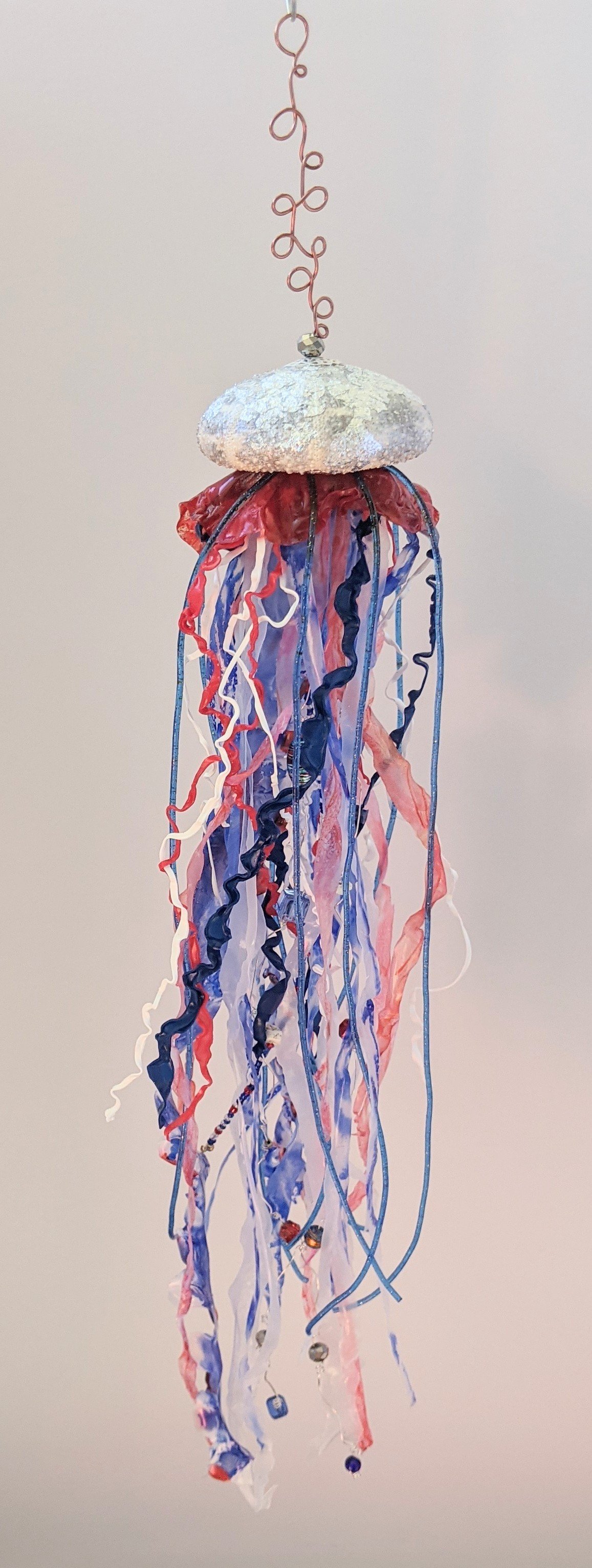 🟢 Available :
Patriotic Jellyfish Suncatcher – Stars & Stripes in Painted Motion by Art Illusions by Young from Folsom, Louisiana. This luminous jellyfish suncatcher celebrates the red, white, and blue of American pride with graceful, flowing beauty
