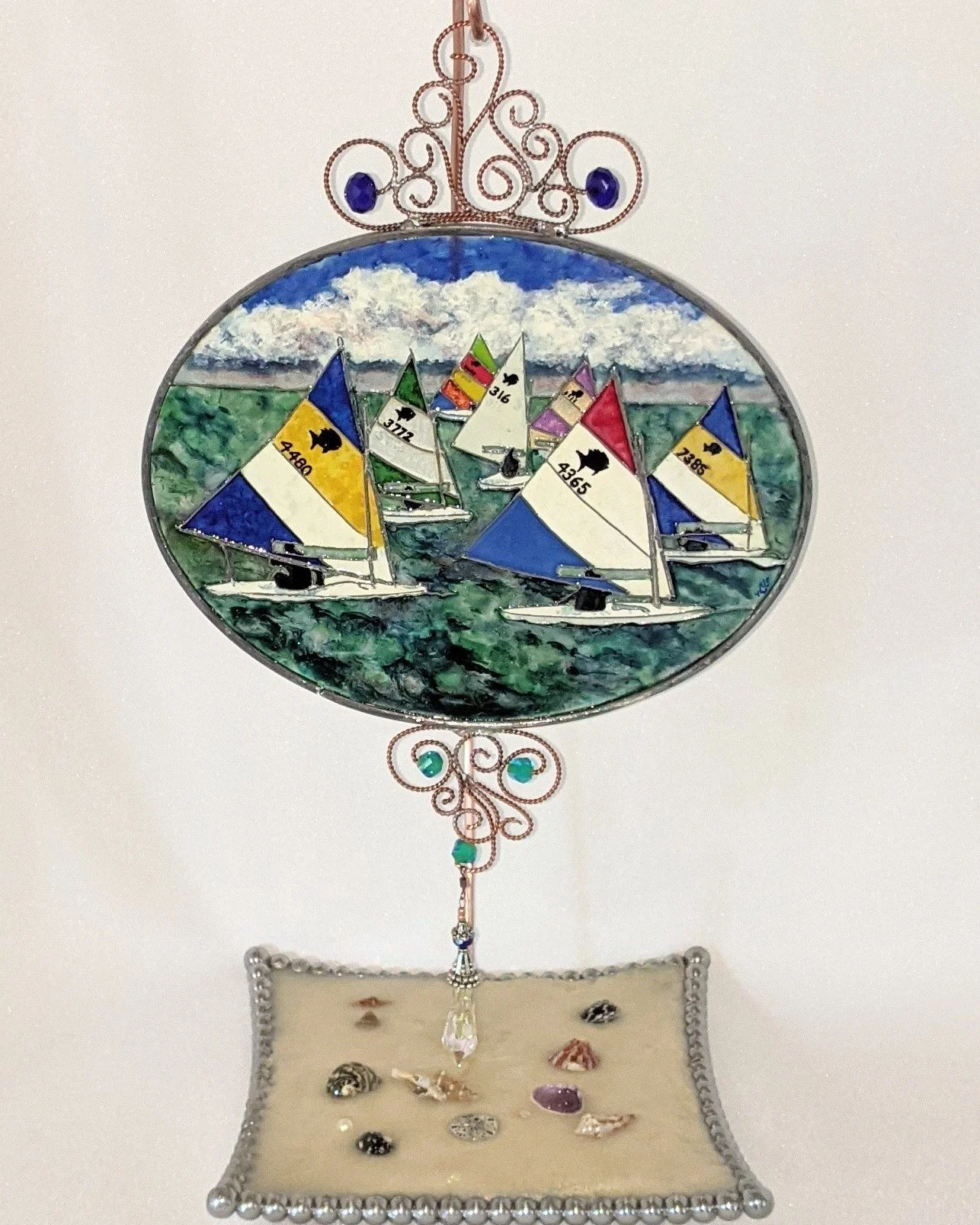 🟢 Available :
Sunfish Regatta by Art Illusions by Young. A vibrant regatta of colorful sunfish sailboats races across sunlit waters in this hand-painted and leaded Illusion Glass panel. Brightly colored sails in yellow, blue, red, and white catch th