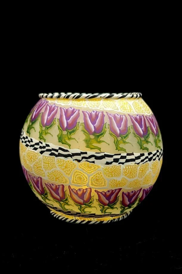 Tulip Bowl by Art Illusions by Young, Folsom, Louisiana. Hand-sculpted polymer clay over glass bowl featuring vibrant purple and red tulips with black-and-white checkered accents and zebra-patterned rim, creating a bold decorative vessel.