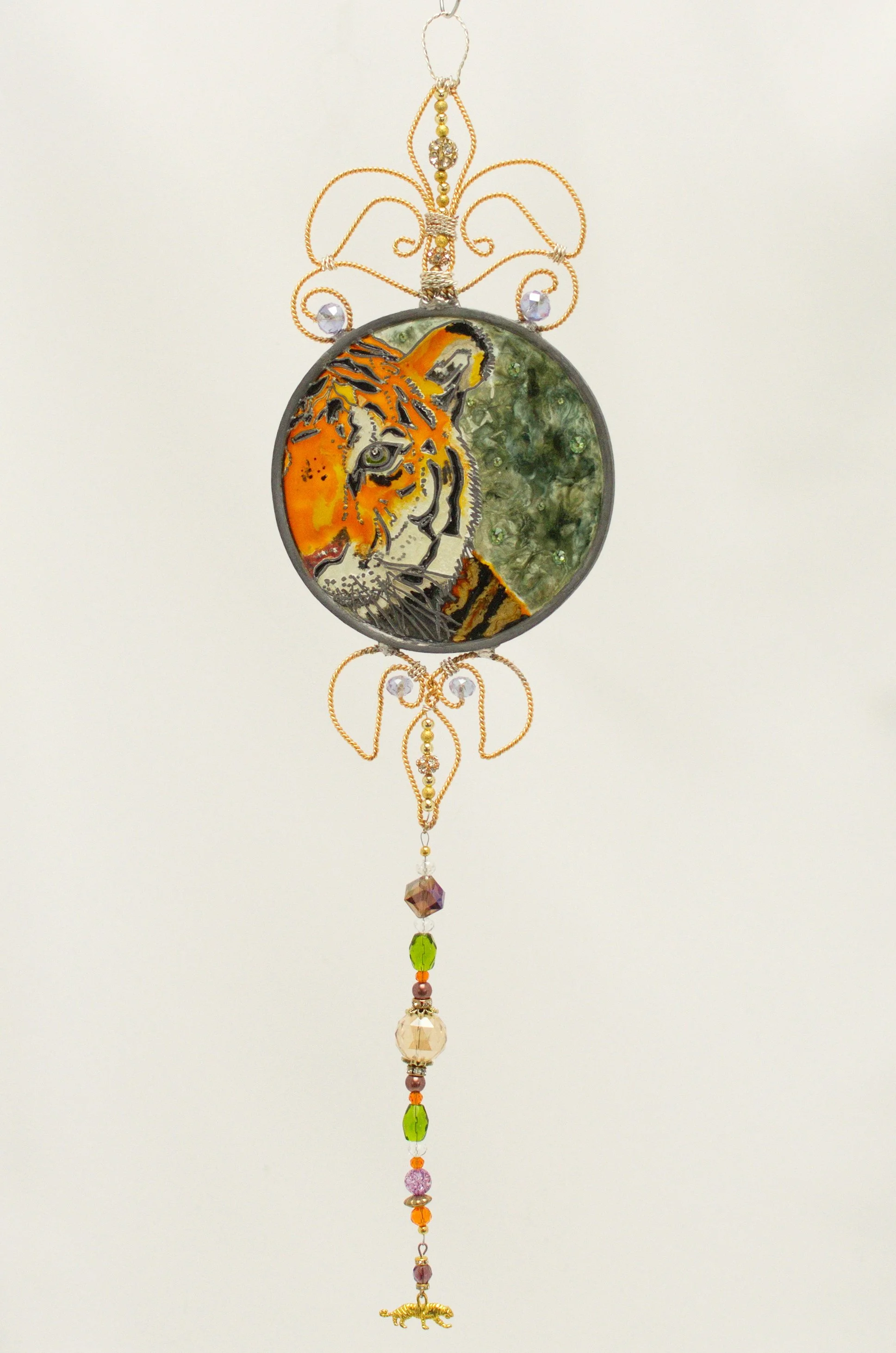 🔴 Sold: 
Tiger Illusion Glass Suncatcher by Art Illusions by Young, Folsom, Louisiana. This powerful circular suncatcher features a majestic tiger with striking orange and black stripes, captured in a dramatic pose against a deep green background. H