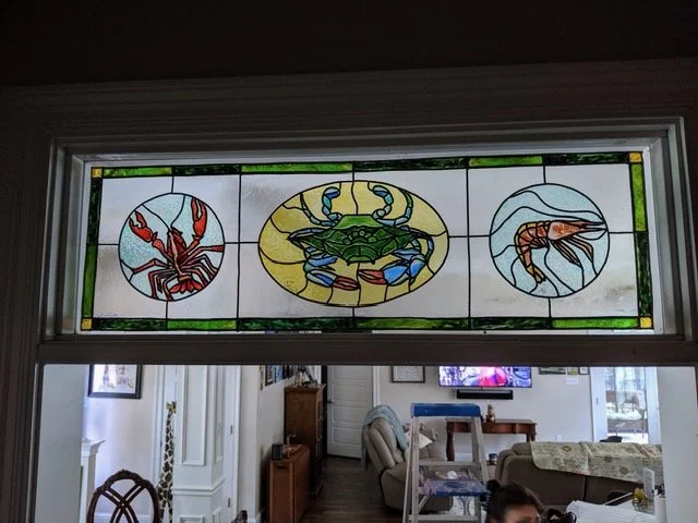 🔵  Donated : 
Door Transom with Crawfish, Blue Crab and Shrimp Illusion Glass by Art Illusions by Young. A vibrant rectangular transom-style suncatcher celebrates Louisiana seafood with a crawfish, blue crab, and shrimp in rich coastal colors. The l