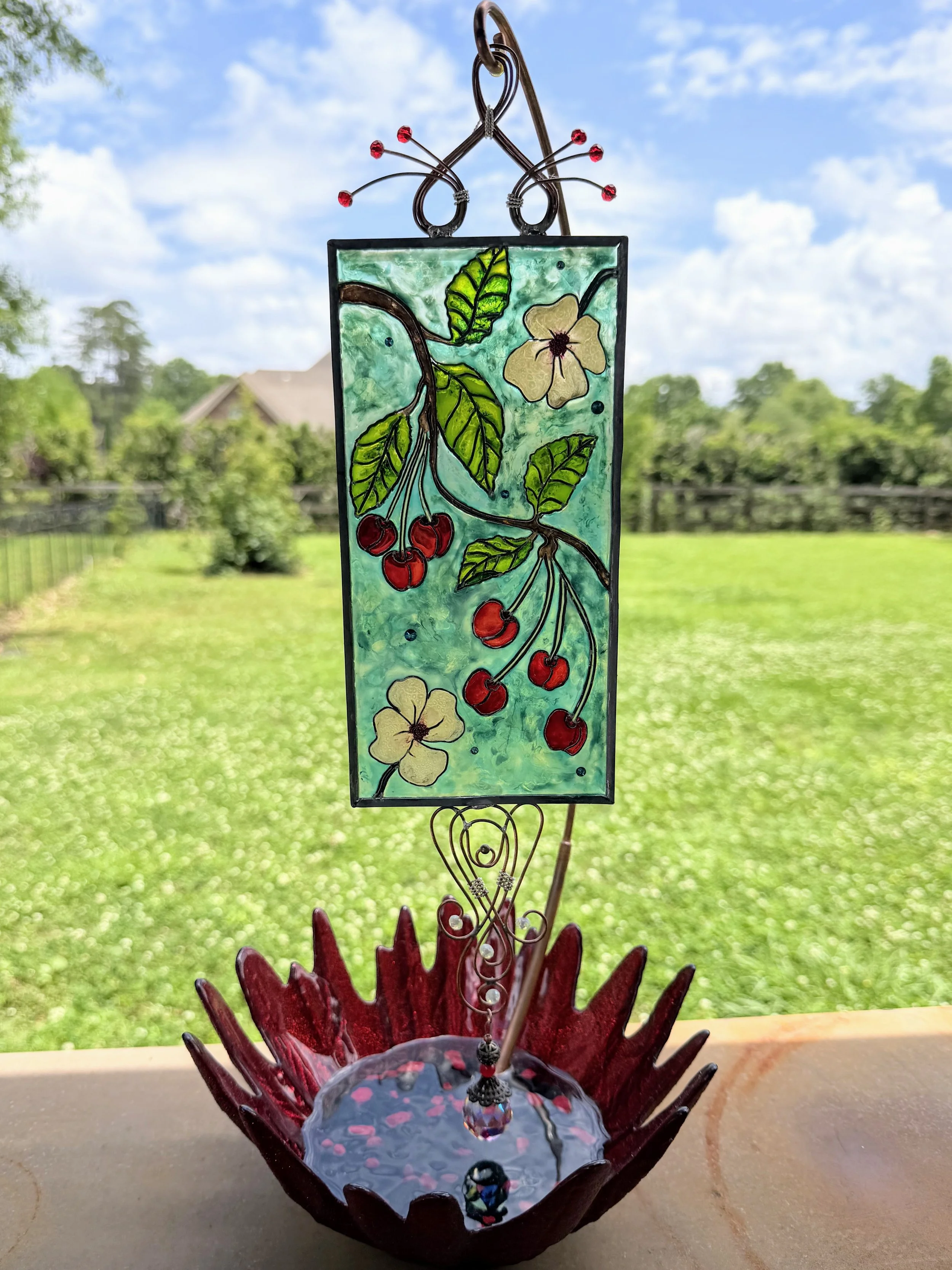 Cherry Jubilee by Art Illusions by Young. A joyful celebration of summer’s bounty bursts with life in this hand-painted and leaded Illusion Glass panel. Clusters of ripe, glossy red cherries hang from delicate branches alongside soft white blossoms a