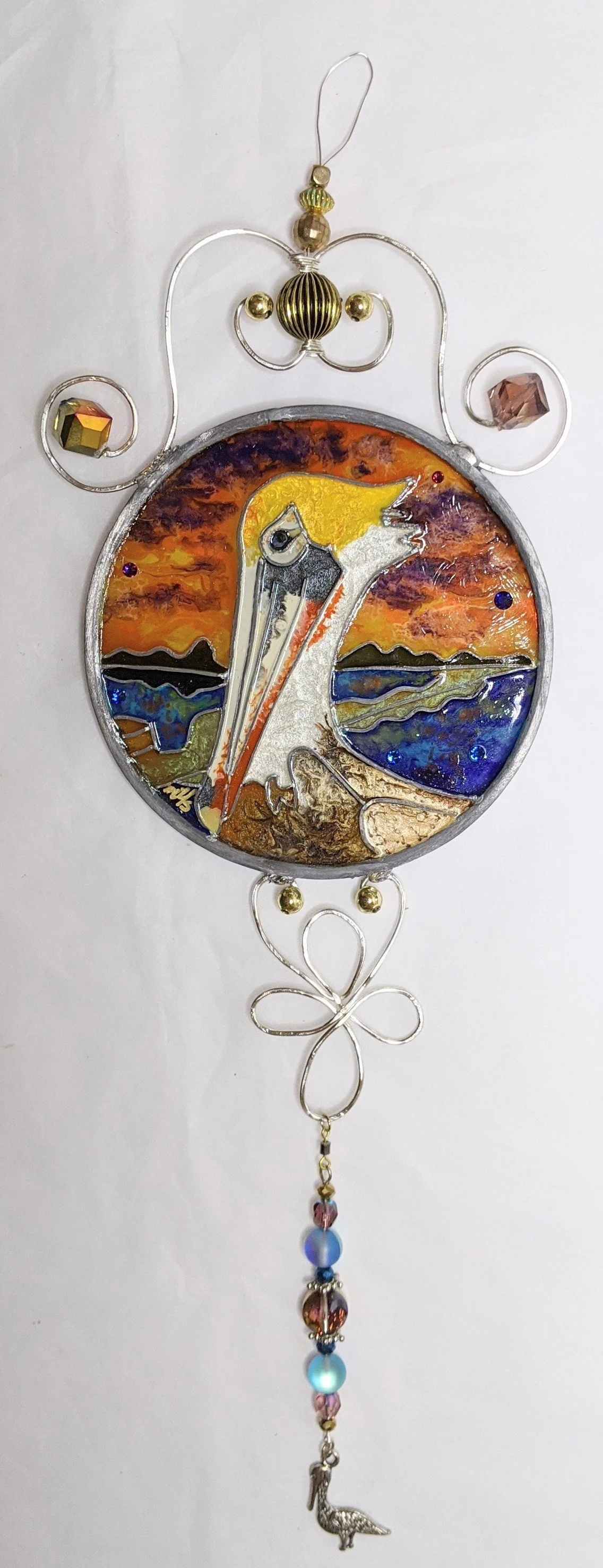🔴 Sold: 
Louisiana Brown Pelican Illusion Glass by Art Illusions by Young. A majestic brown pelican sits near coastal waters, against a soft sky, in this round suncatcher . Realistic details and subtle color layering bring Louisiana’s iconic seabird