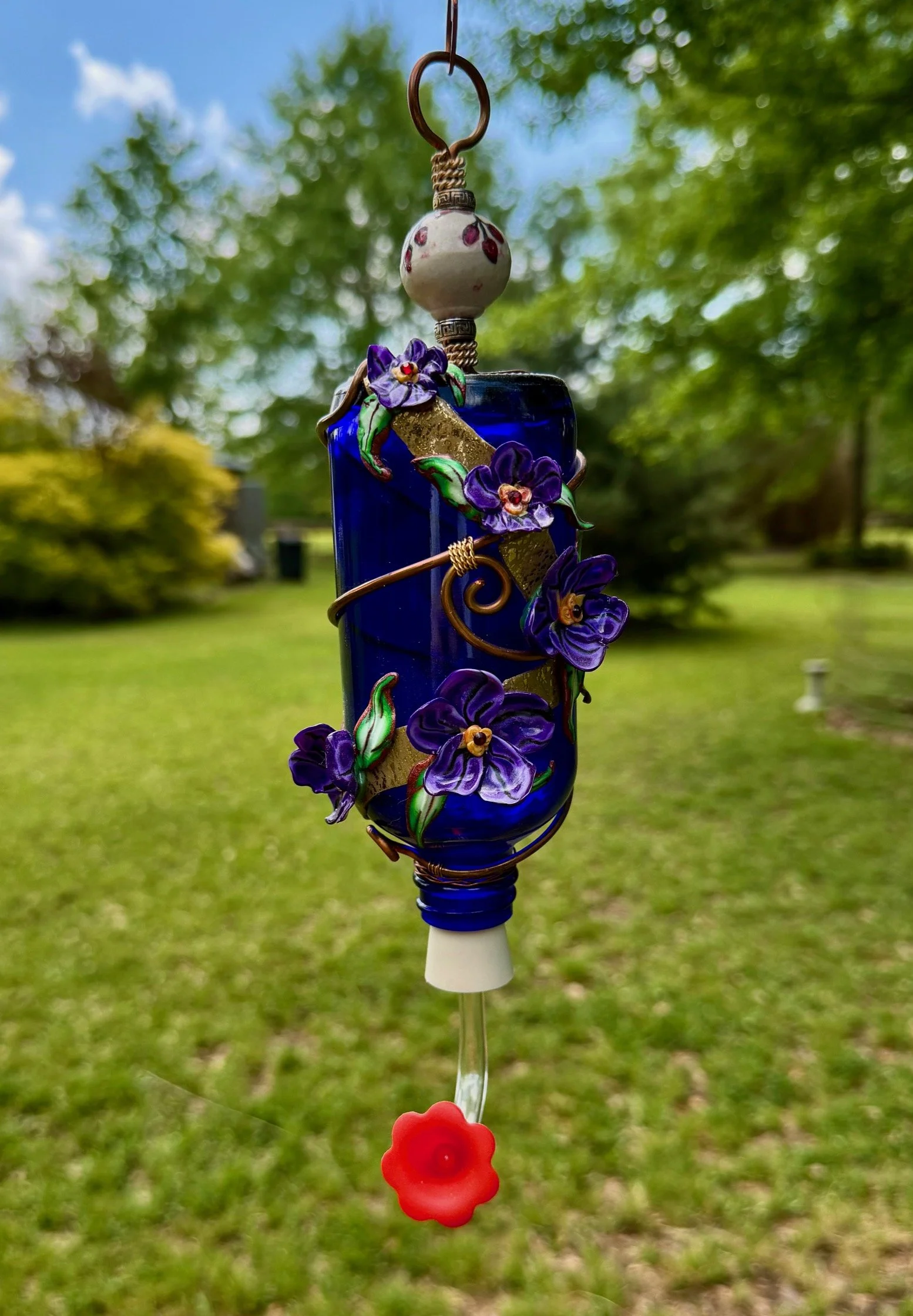 Hummingbird Feeder Purple Pansy Elegance by Art Illusions by Young from Folsom, Louisiana. A deep cobalt blue glass bottle is transformed into a functional work of art with elegant copper wire wrapping shaped in graceful vines and tendrils. Hand-scul
