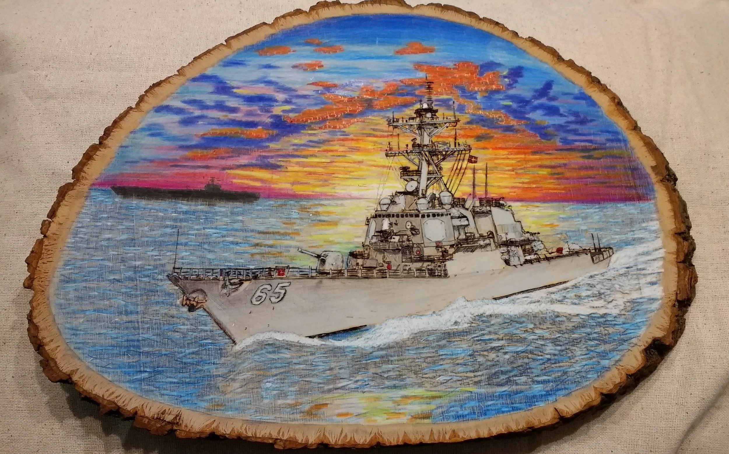 USS Benfold DDG-65 at Datbreak by Art Illusions by Young, Folsom, Louisiana. Hand-burned pyrography on basswood depicting the Arleigh Burke-class destroyer USS Benfold at sea with as aircraft carrier in silhouette against a glowing daybreak sky.