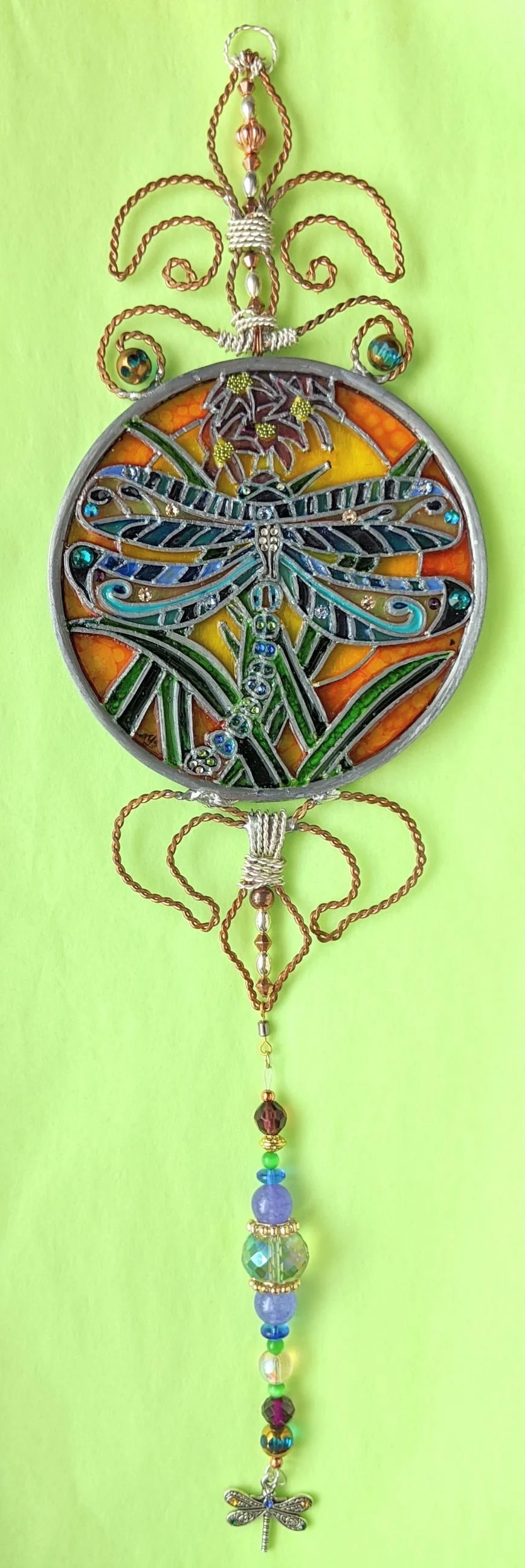🔴 Sold: 
Dragonfly Illusion Glass by Art Illusions by Young. This graceful dragonfly hovers with iridescent wings in a round suncatcher, surrounded by subtle aquatic accents. The hand-painted details create shifting patterns of light and color that 