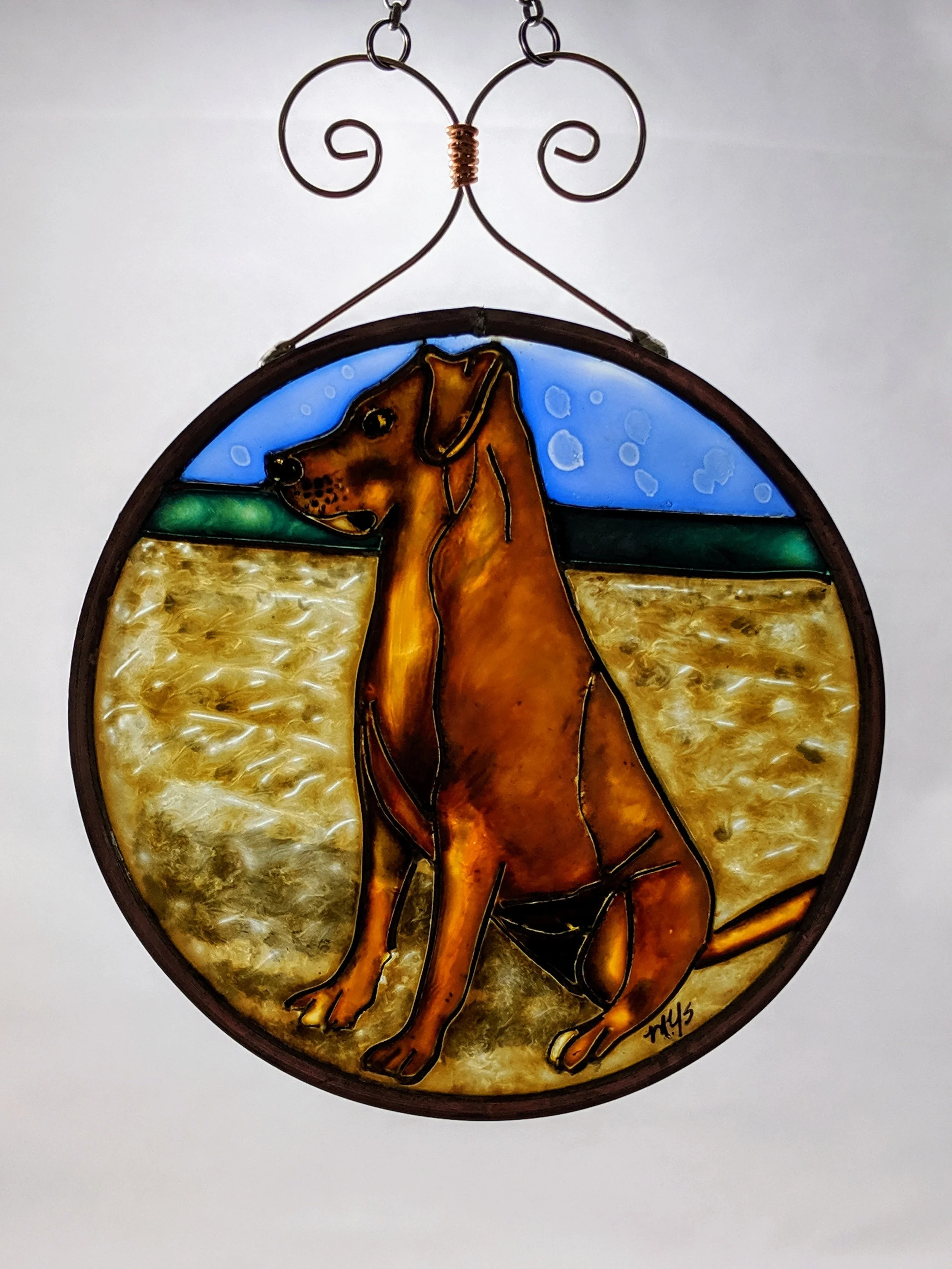 🔴 Sold: 
Yellow Dog on the Beach Illusion Glass by Art Illusions by Young, Folsom, Louisiana. This warm circular suncatcher captures a golden-yellow dog sitting peacefully on a sandy beach with gentle waves and a clear blue sky. Hand-painted with Eu