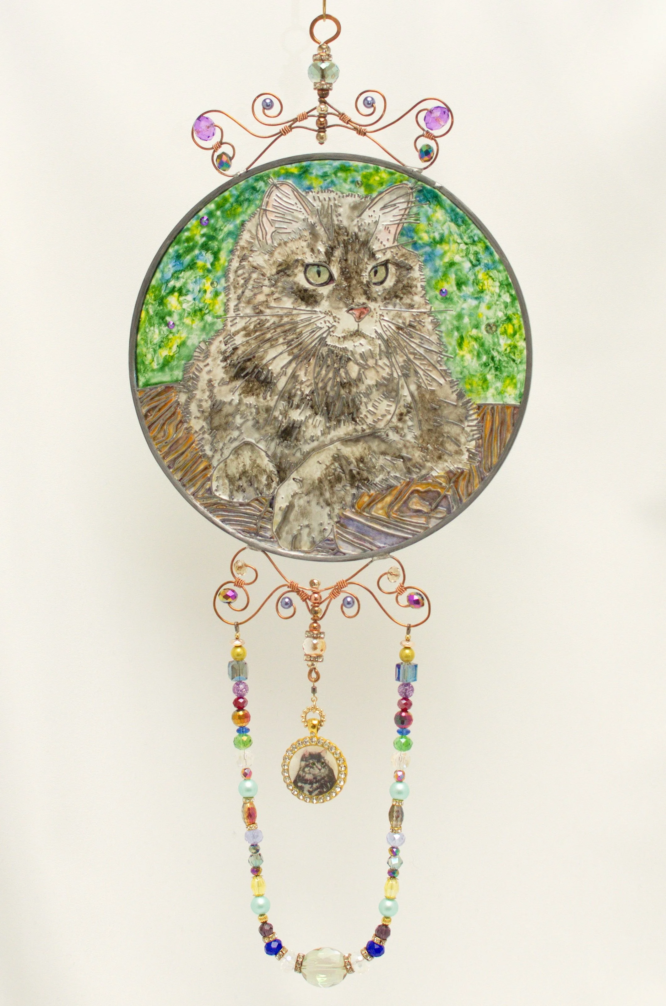 🔴 Sold: 
Maine Coon Cat Illusion Glass by Art Illusions by Young. This charming circular piece portrays a fluffy Maine Coon cat with expressive eyes and luxurious fur, surrounded by soft green accents. The hand-painted details on leaded glass create