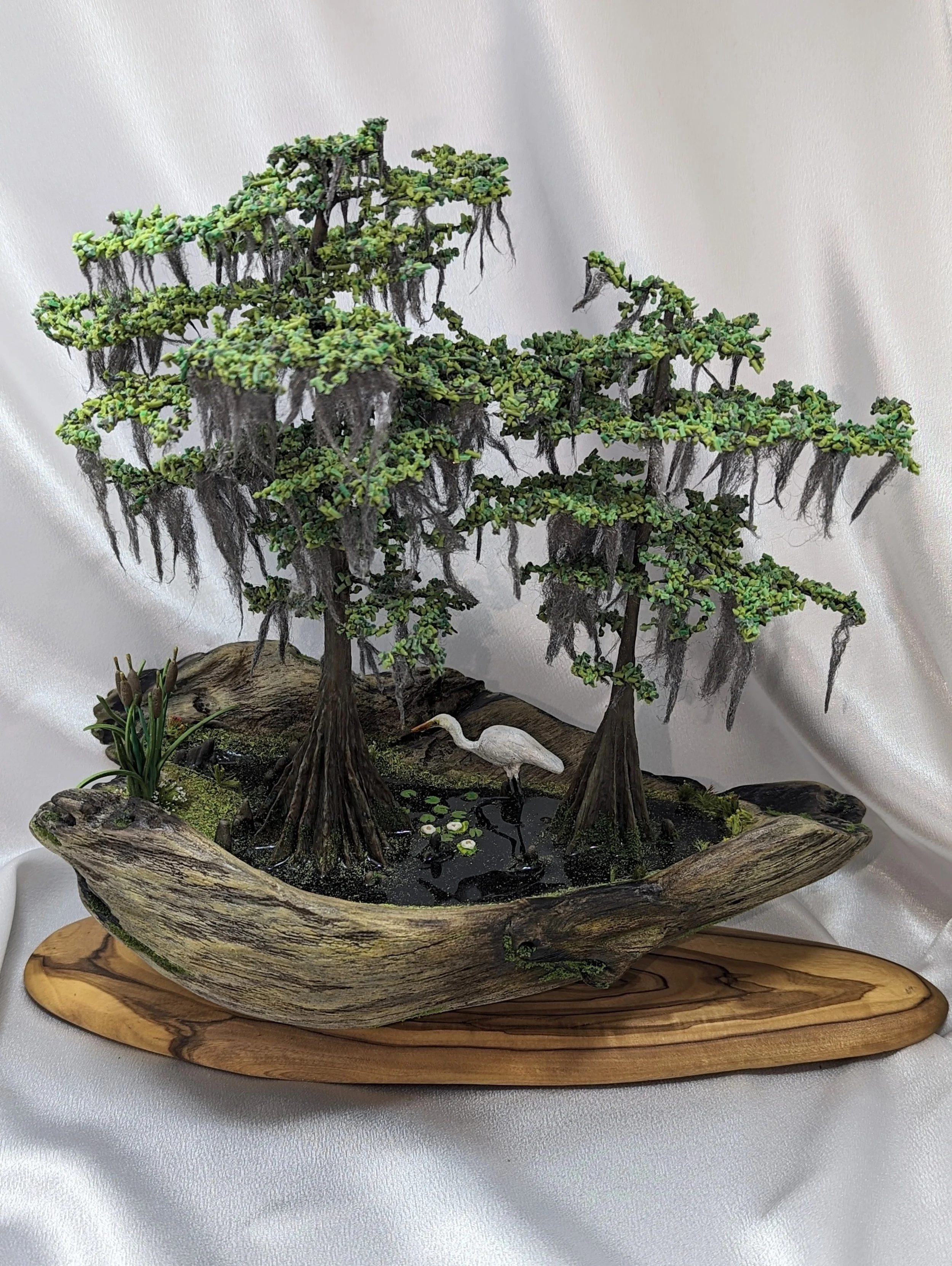 Still Waters Silent Watch micro swamp bonsai diorama by Art Illusions by Young. Twin cypress trees with Spanish moss on sinker cypress slab base with epoxy pond, hand-sculpted egret, lily pads and cattails. 110 hours work.