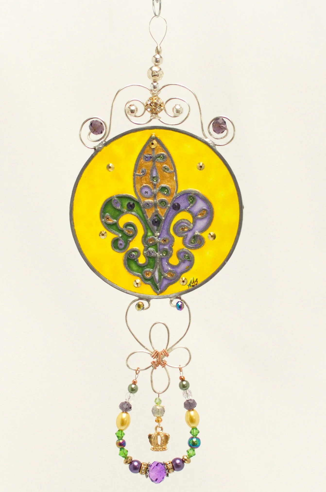 🔴 Sold: 
Fleur-de-Lis Illusion Glass by Art Illusions by Young. A second striking fleur-de-lis design in this round suncatcher, featuring vibrant gold, green, and purple detailing against a bright yellow background. Hand-painted with care to honor L