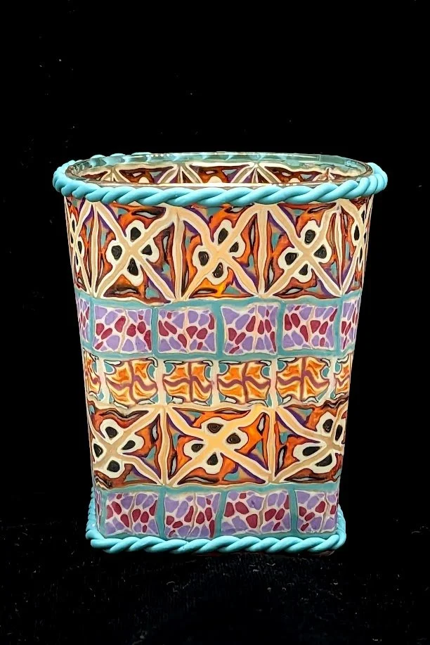 Colorful Geometric Trinket Holder by Art Illusions by Young, Folsom, Louisiana. Hand-sculpted polymer clay over glass vessell featuring intricate multicolored tile-like patterns in turquoise, orange, purple, and cream with braided rope accents.