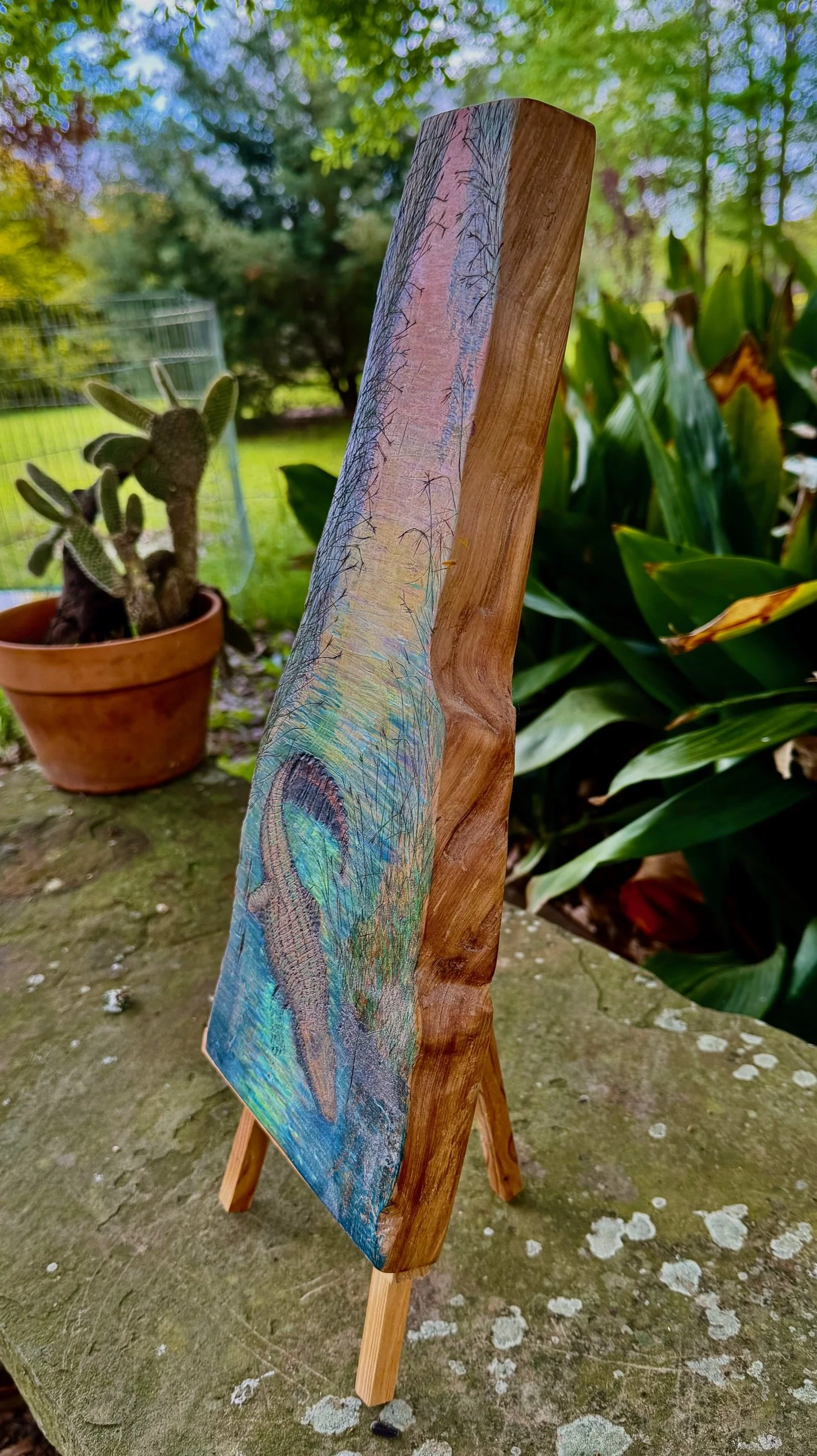 Right angled view of Bayou Guardian – Alligator on Live-Edge Cypress by Art Illusions by Young. The live-edge cypress slab showcases rich natural grain while the hand-burned alligator emerges from deep blue-green waters. Positioned on an easel with p