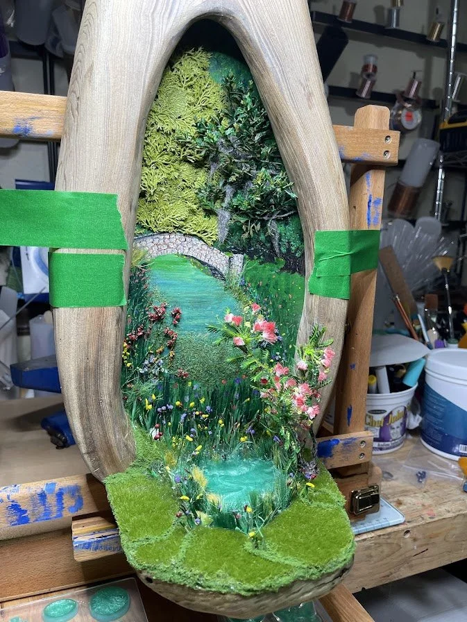 Preparing the final stages of the Enchanted City Park Serenity diorama, showing the hollow cypress tree trunk with miniature park scene and green tape markers to hold the artwork in place while curing. Handcrafted mixed media art by Art Illusions by 