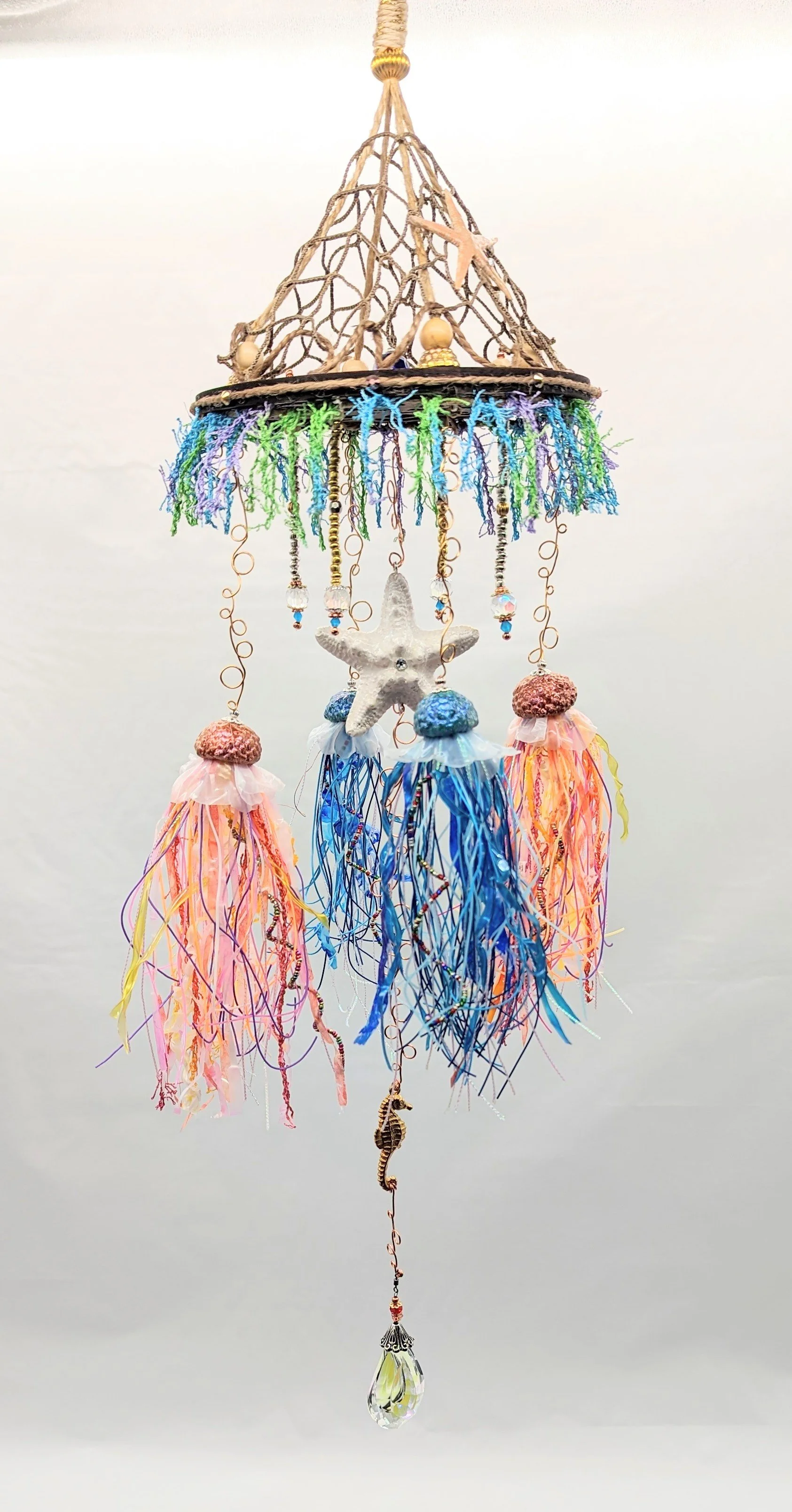 🟢 Available :
Jellyfish Mobiles – Chihuly-Inspired Light Catcher by Art Illusions by Young from Folsom, Louisiana. This luminous art mobile features a decorative and authentic netted canopy — sisal-wrapped and suspended from a walnut laser-cut woode