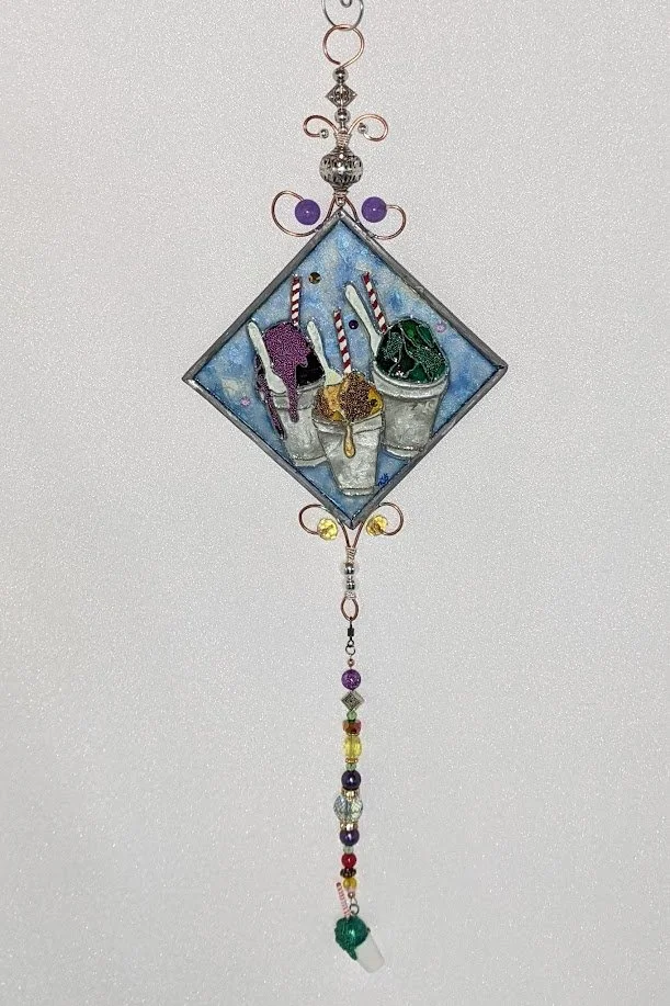 New Orleans Snowballs Illusion Glass by Art Illusions by Young, Folsom, Louisiana. Diamond-shaped hand-painted leaded glass artwork featuring colorful shaved-ice snowballs in classic New Orleans flavors , framed in copper wire with crystal dangles.