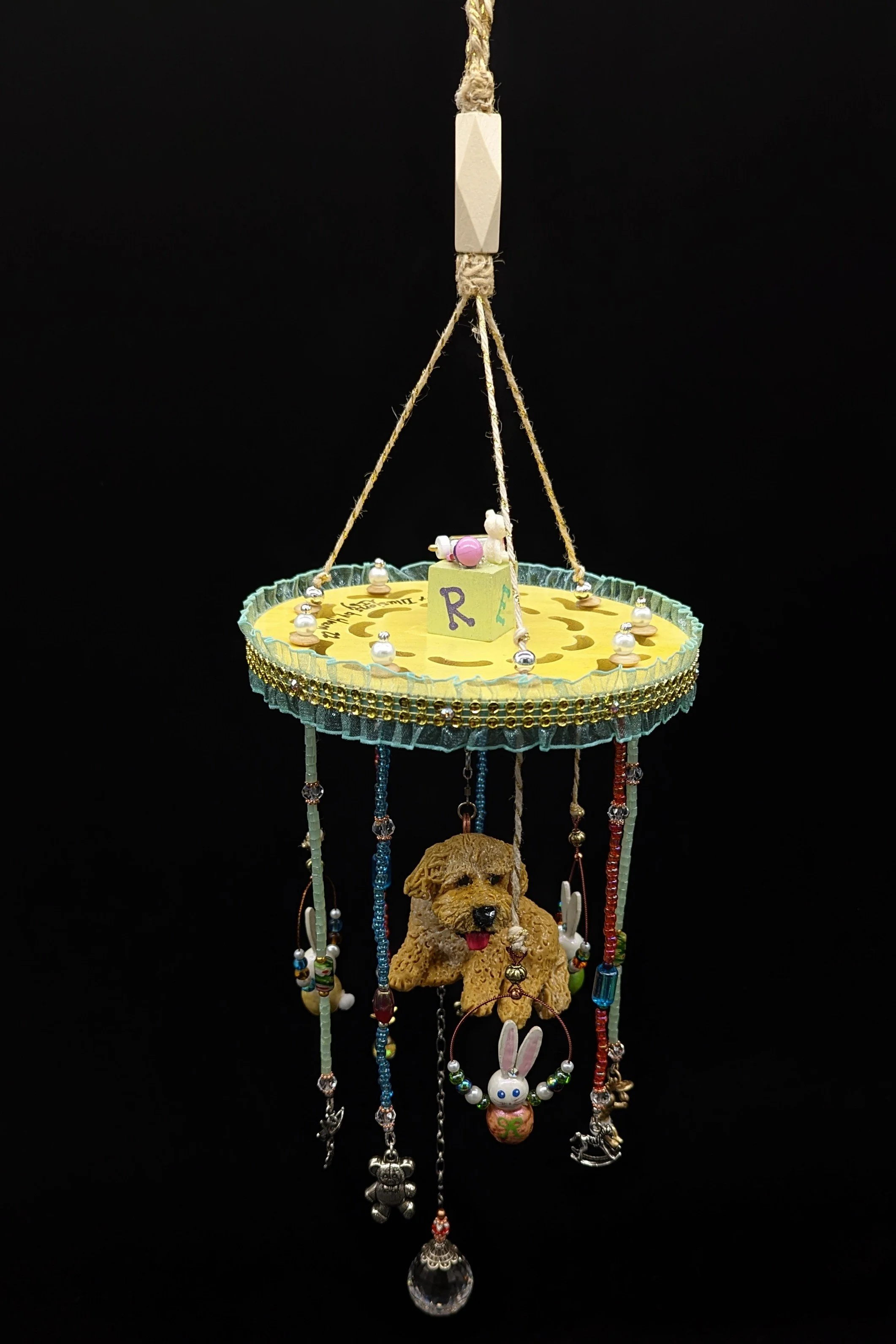 Full hanging view of the Puppy Commission Mobile by Art Illusions by Young. Neutral tones of yellow, lime, seafoam, sunset, teal, gold, and silver create a soft, harmonious palette. The hand-sculpted Puppy and surrounding childhood elements are balan