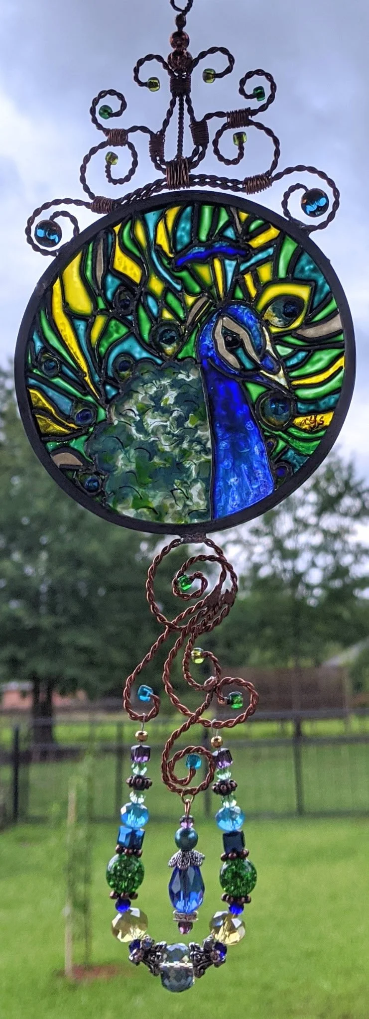 🔴 Sold: 
Peacock Illusion Glass Suncatcher by Art Illusions by Young, Folsom, Louisiana. This stunning circular suncatcher features a majestic peacock with its tail fully displayed in vibrant shades of blue, green, and gold against a lush background