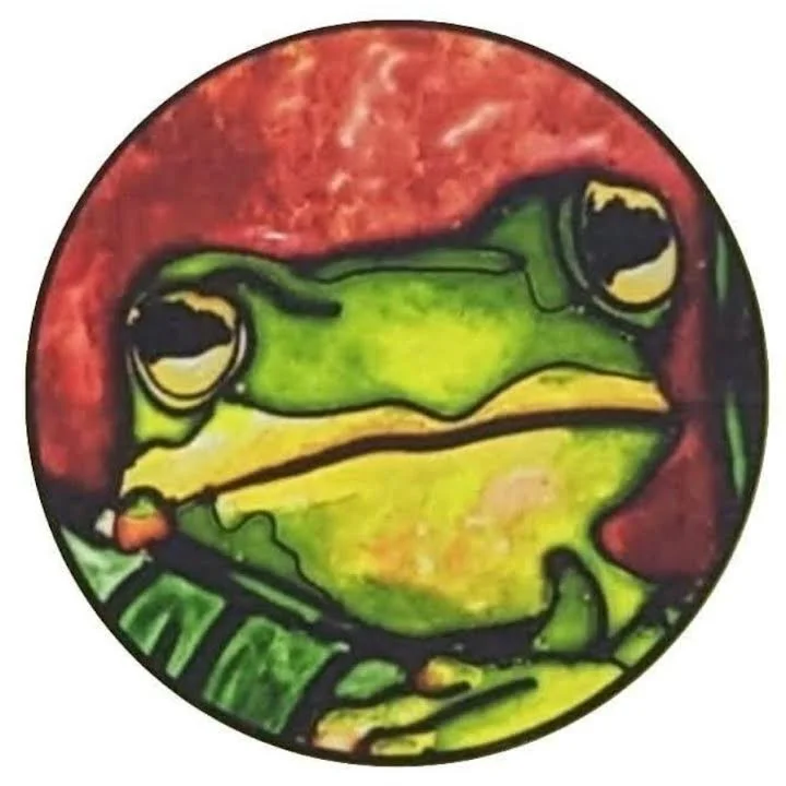Original frog Illusion Glass logo created by Mark and Sandra Young of Art Illusions by Young, Folsom, Louisiana. Hand-painted leaded glass rounf suncatcher featuring a vibrant green tree frog on a red background, the first Illusion Glass piece.