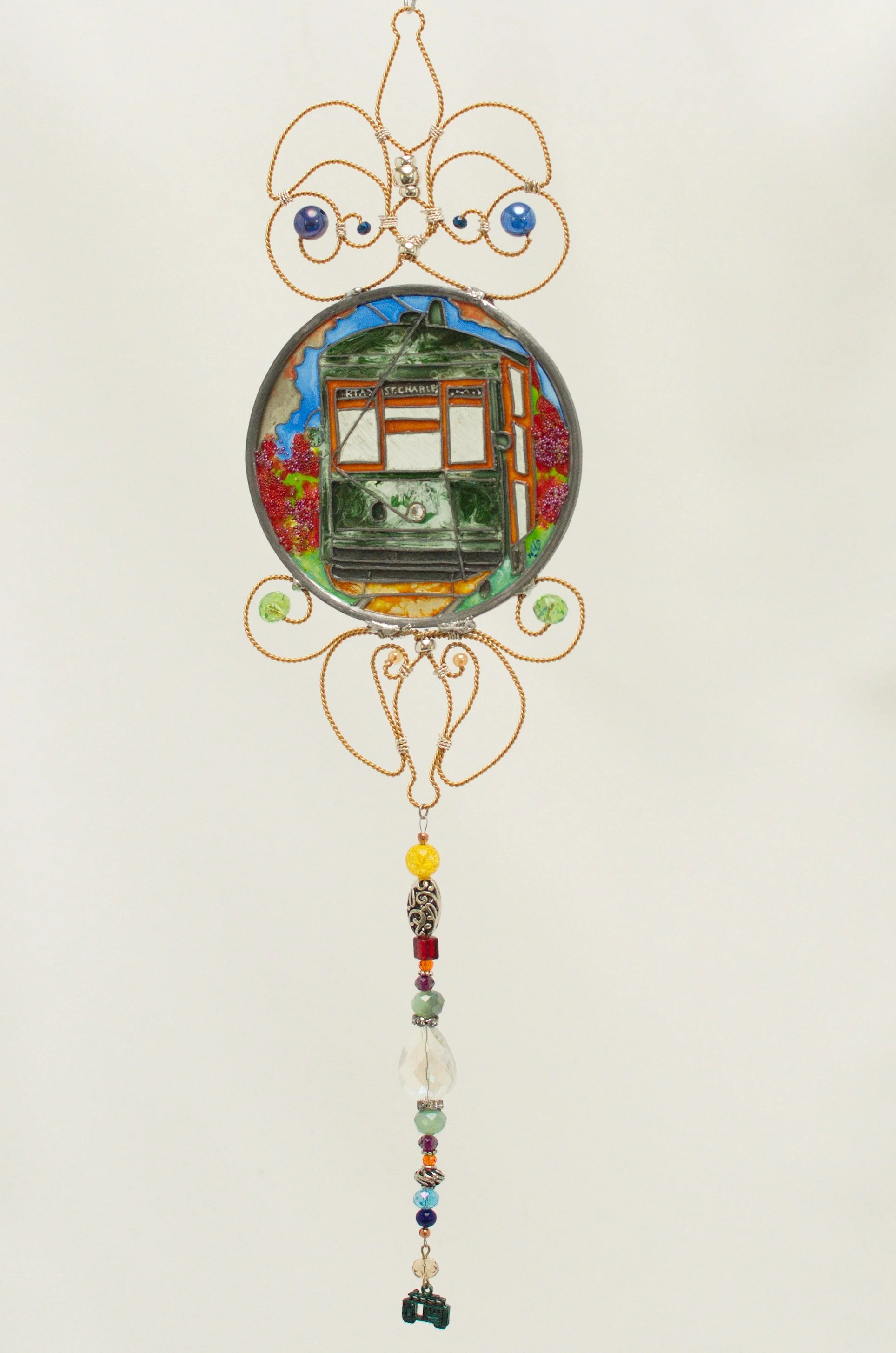 🔴 Sold: 
New Orleans Streetcar Illusion Glass by Art Illusions by Young. The iconic green St. Charles Avenue streetcar glides past live oaks in this luminous circular suncatcher. Hand-painted details capture the romance and history of New Orleans tr